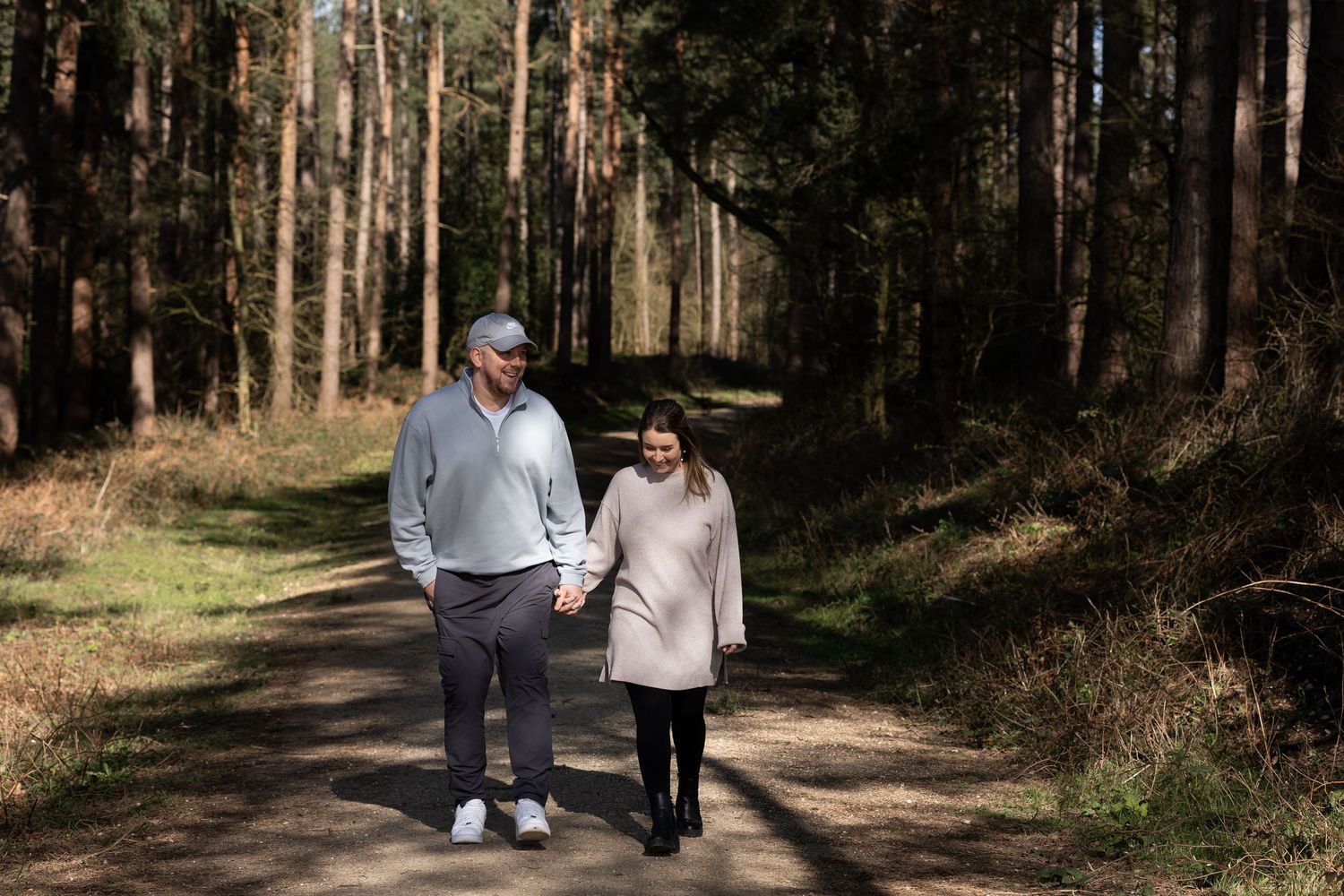 A couple walking hand in hand in the woods. Natural documentary photography, Nottingham.