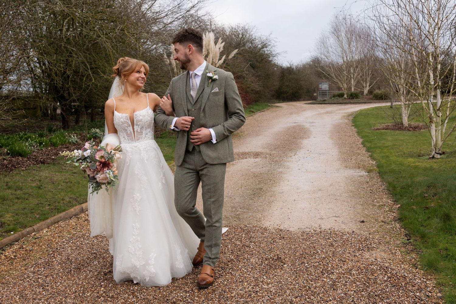 Bride and groom walking candidly arm in arm at The Carriage Hall in Nottingham