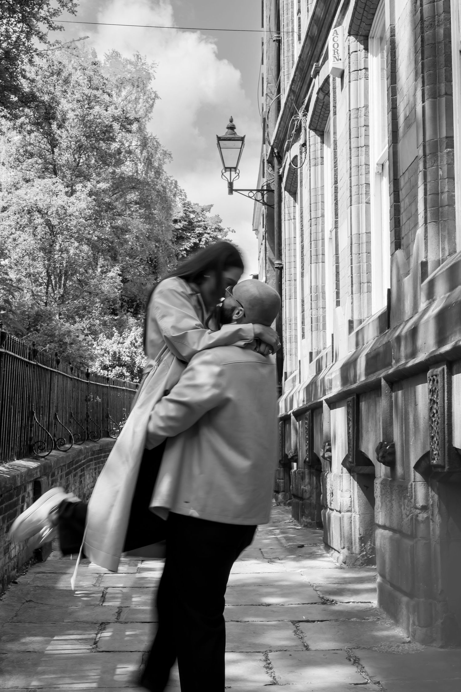 Male spinning female around in the air during their engagement shoot. Romantic kiss. Natural documentary photography