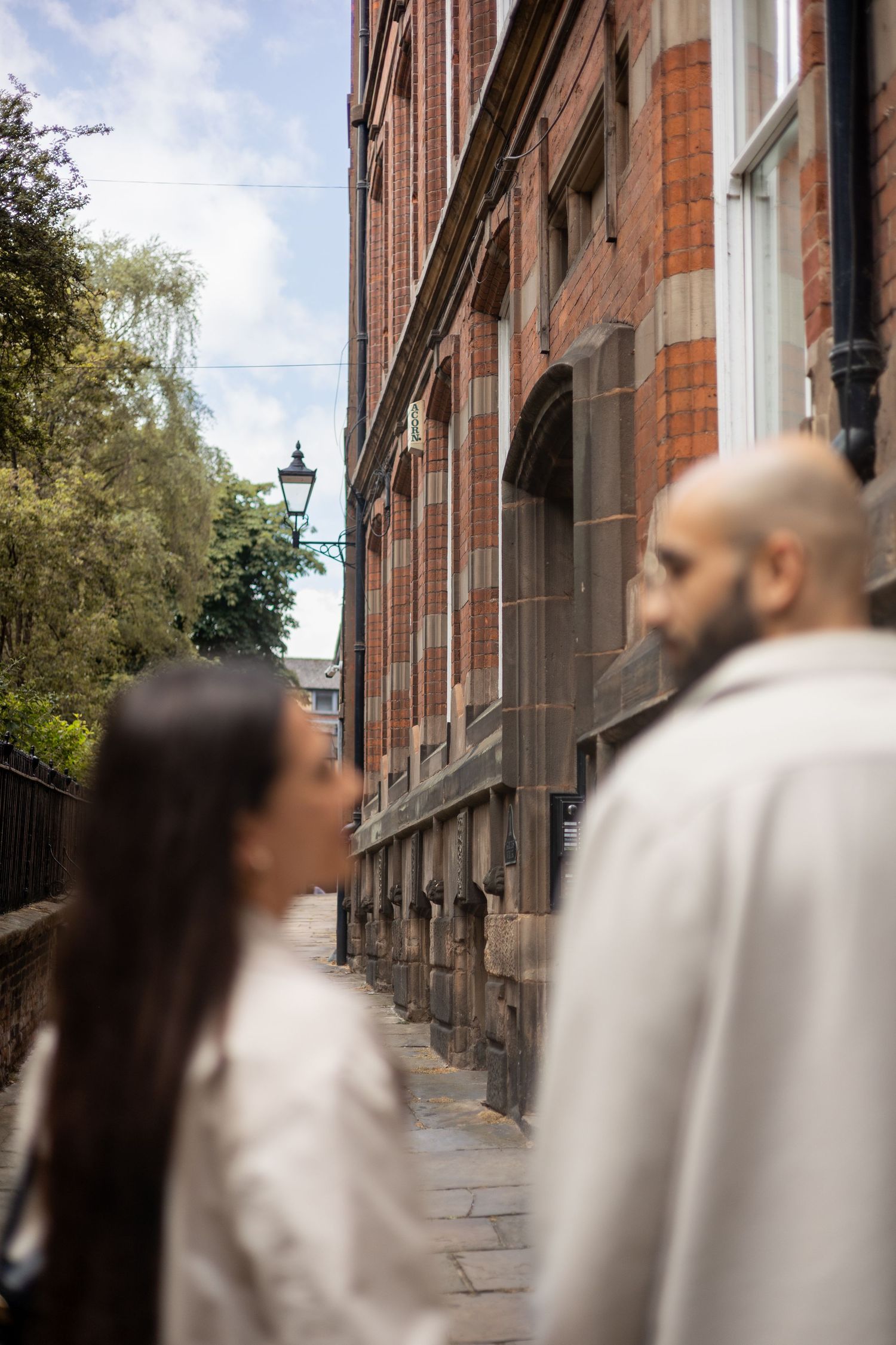 Couple hand in hand walking down the streets of Nottingham. Buildings in focus.