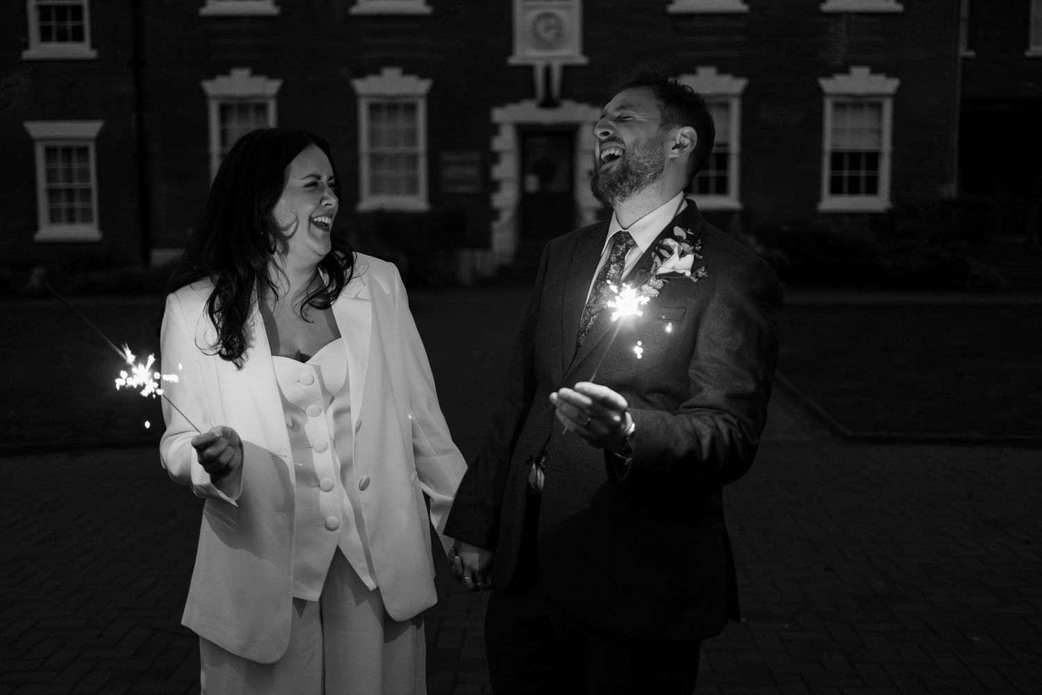 Bride and groom full of joy with sparklers at their twilight Christmas wedding at West Bridgford Registry Office