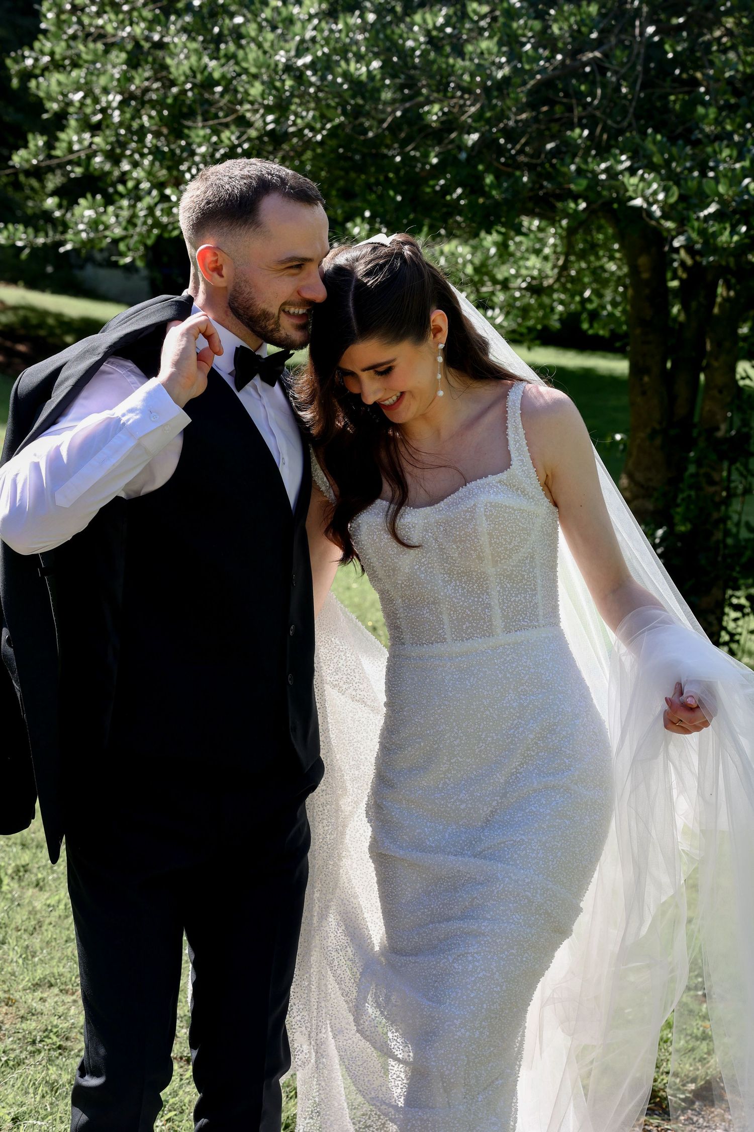 Couple walking back from the ceremony close together and chatting, laughing candidly. Natural documentary weddings