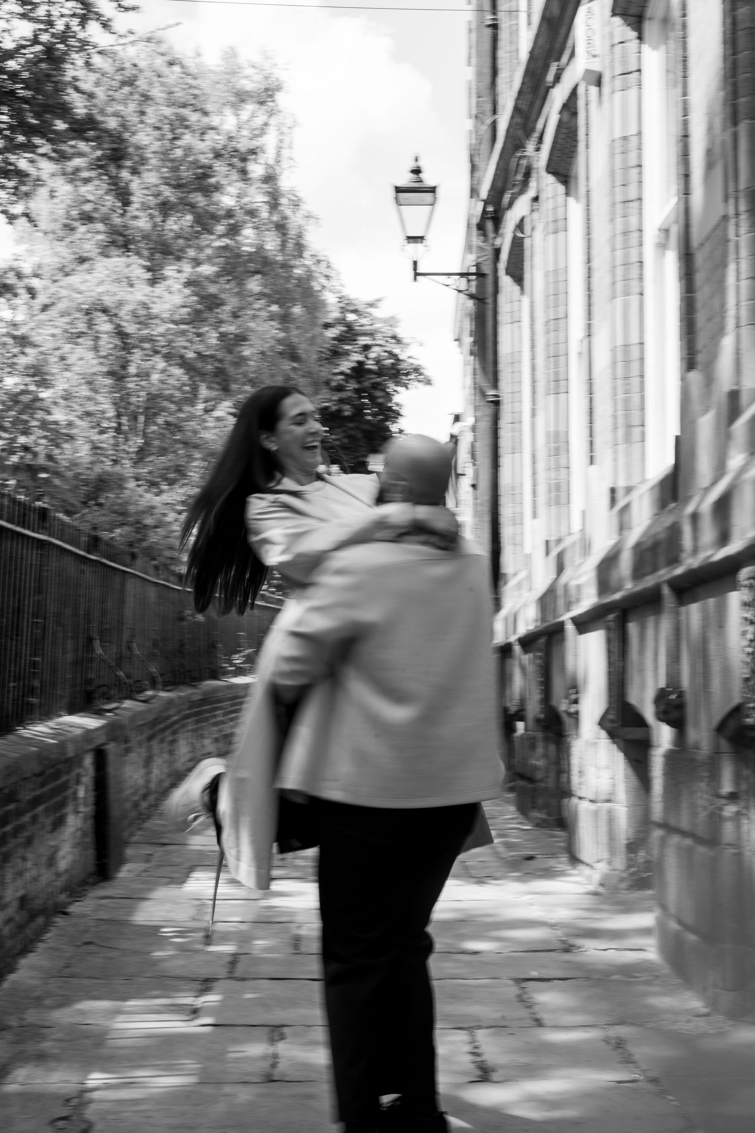 Male spinning female around in the air during their engagement shoot. Natural documentary photography