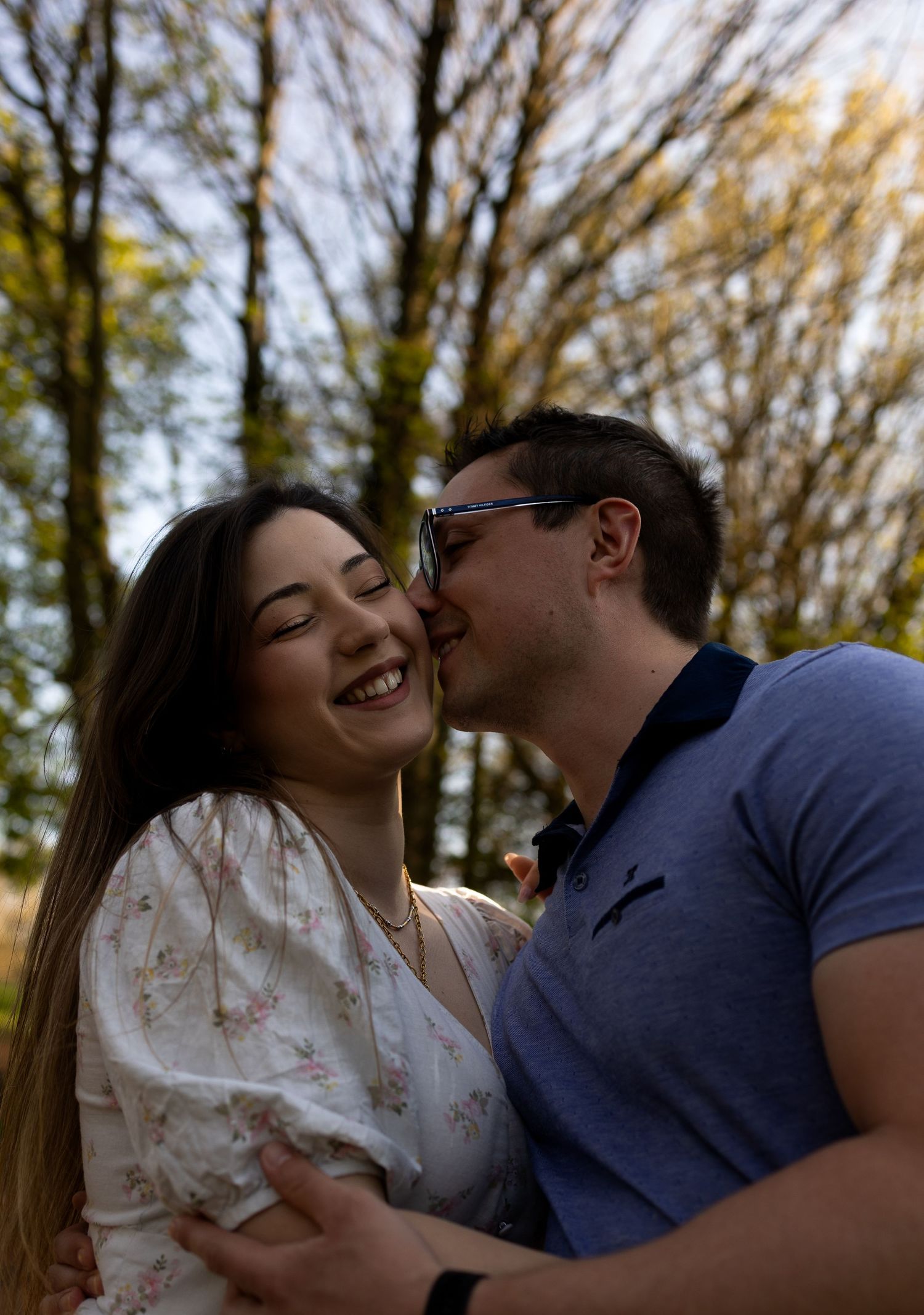 Fiance planting a kiss on his soon to be wife's cheek. Both smiling. Natural documentary wedding photography