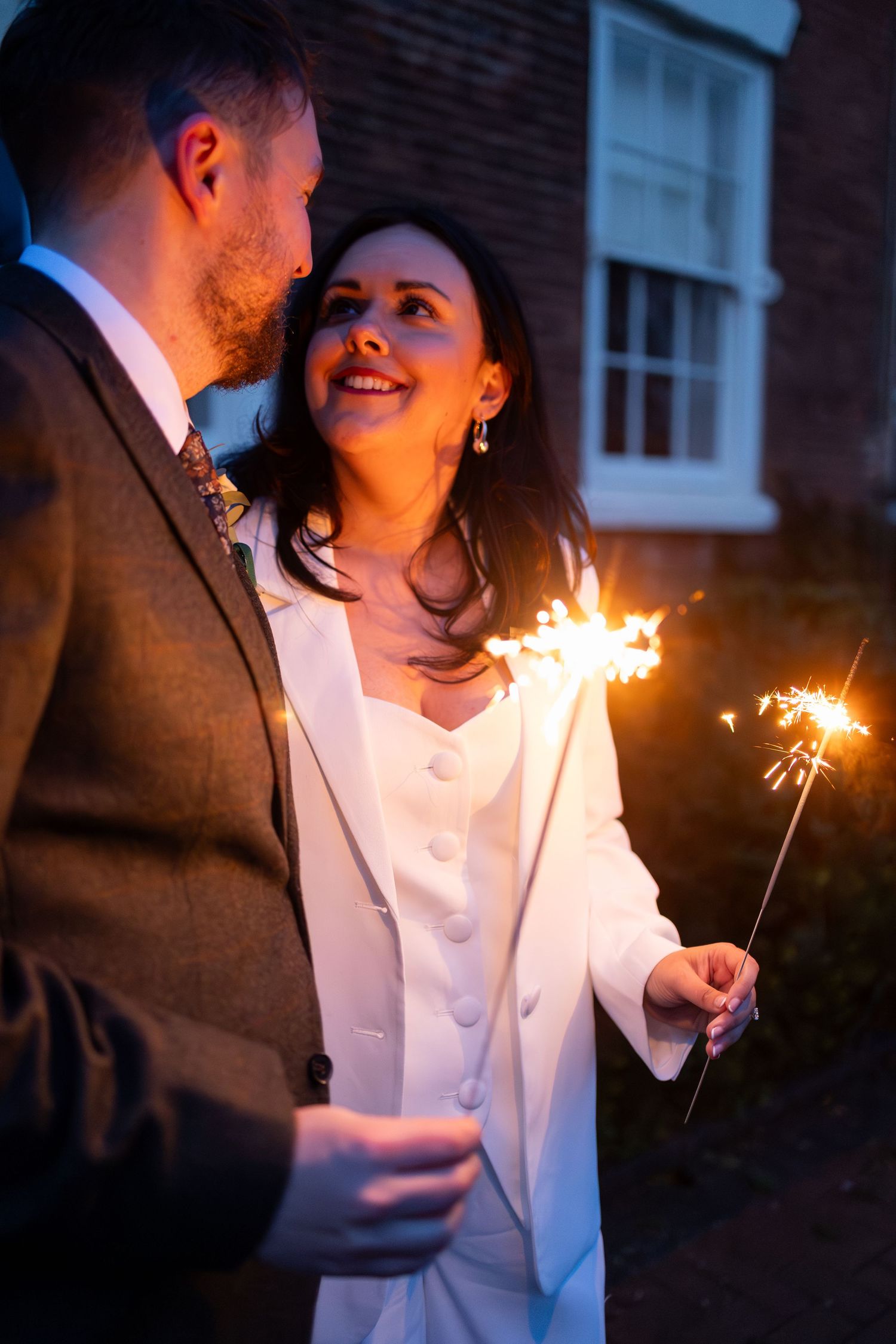 Bride and groom full of joy with sparklers at their twilight Christmas wedding at West Bridgford Registry Office