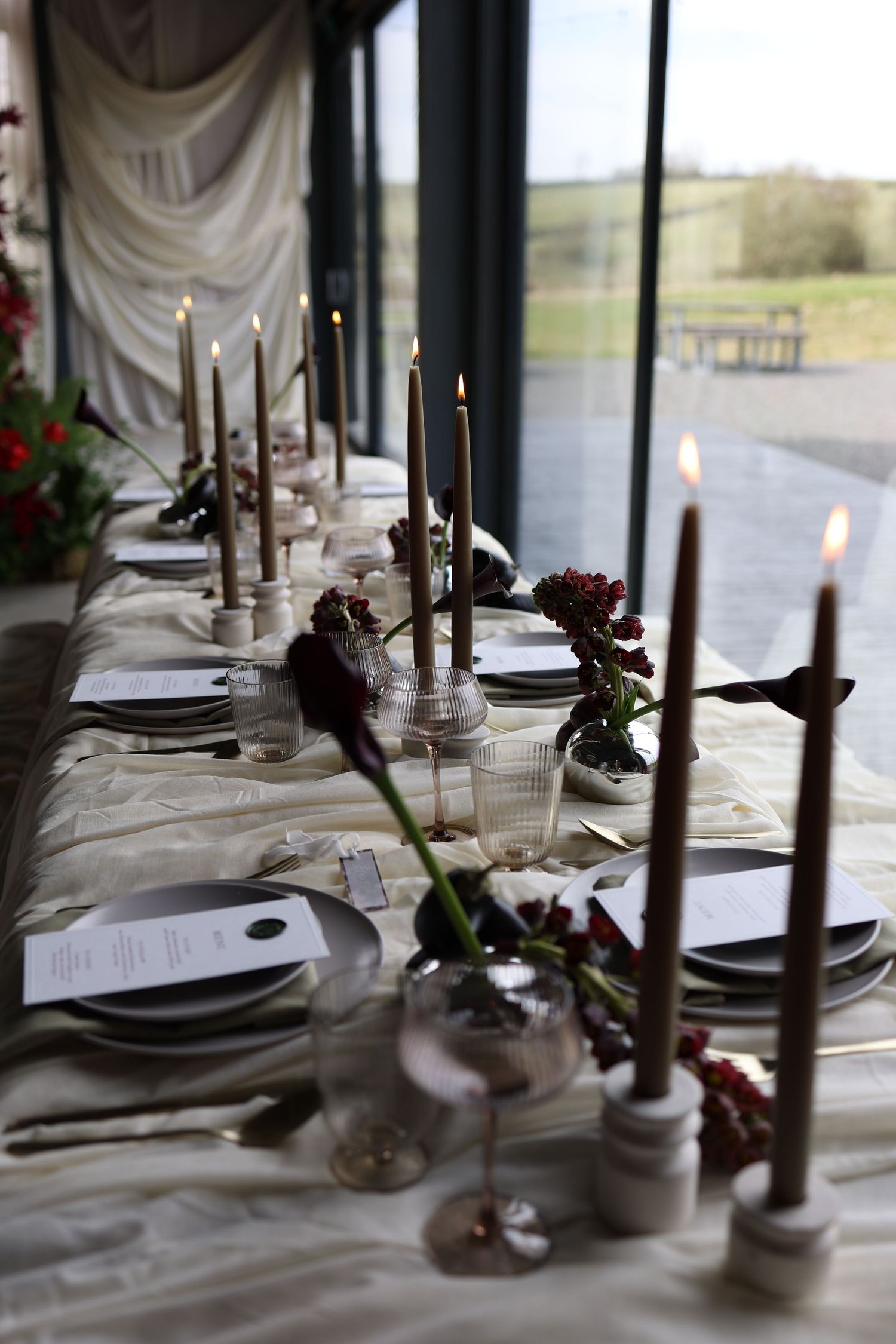 Olive green table set up. Long lit candles and gorgeous wax stamped menus with simple florals.