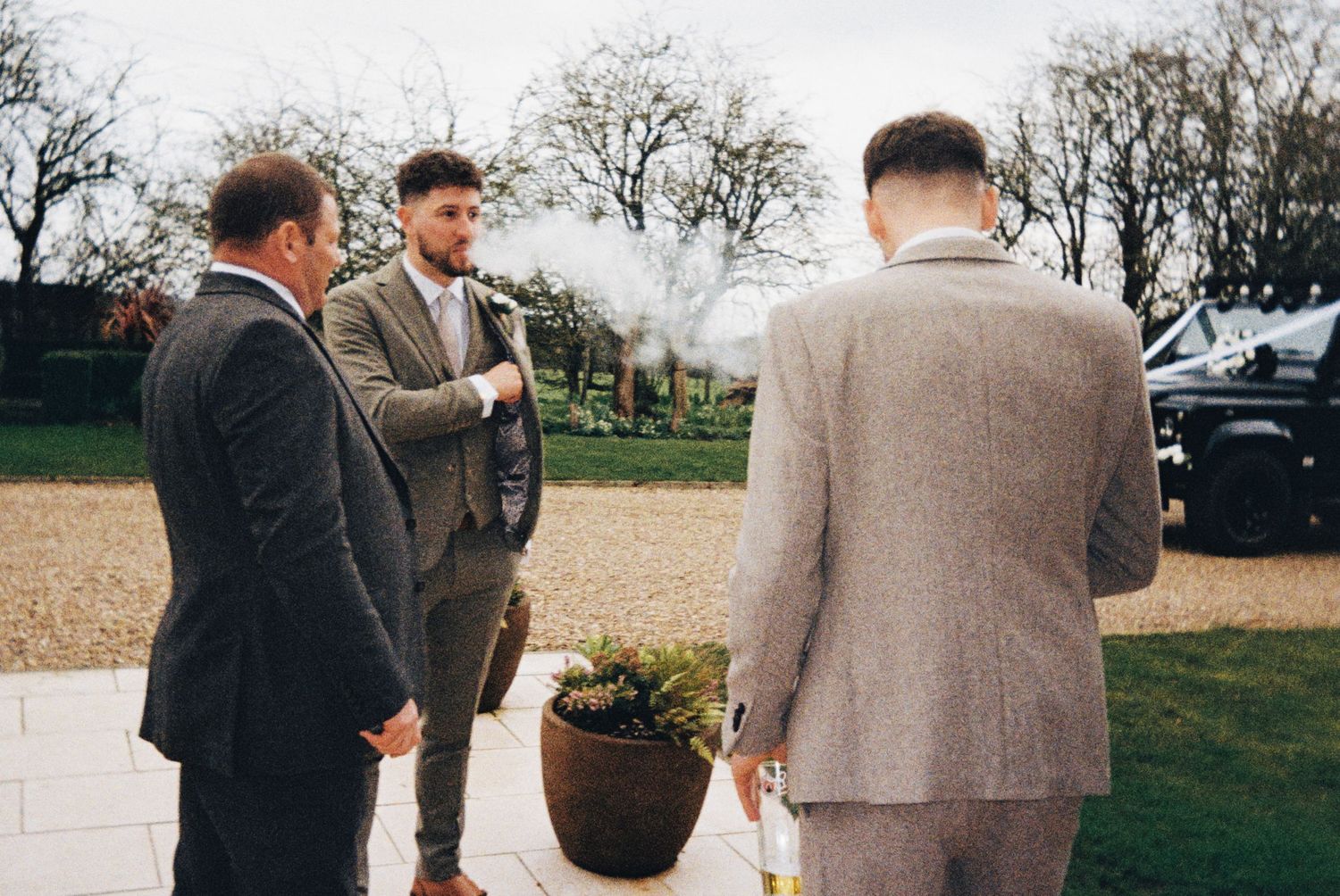 The groom sharing a wedding cigar with his dad and brother. Documentary style. Taken on 35mm Film at The Carriage Hall, Nottingham.