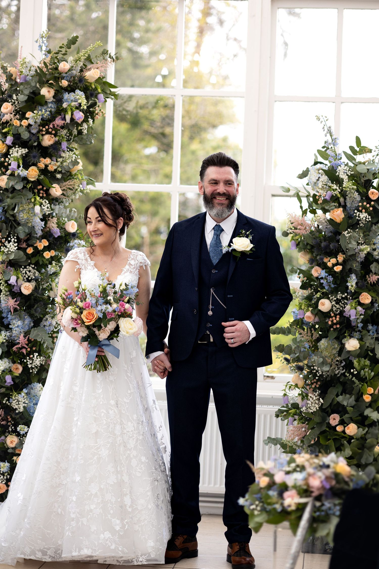 Couple looking at their guests after the ceremony smiling. Full of joy. Natural documentary wedding photography