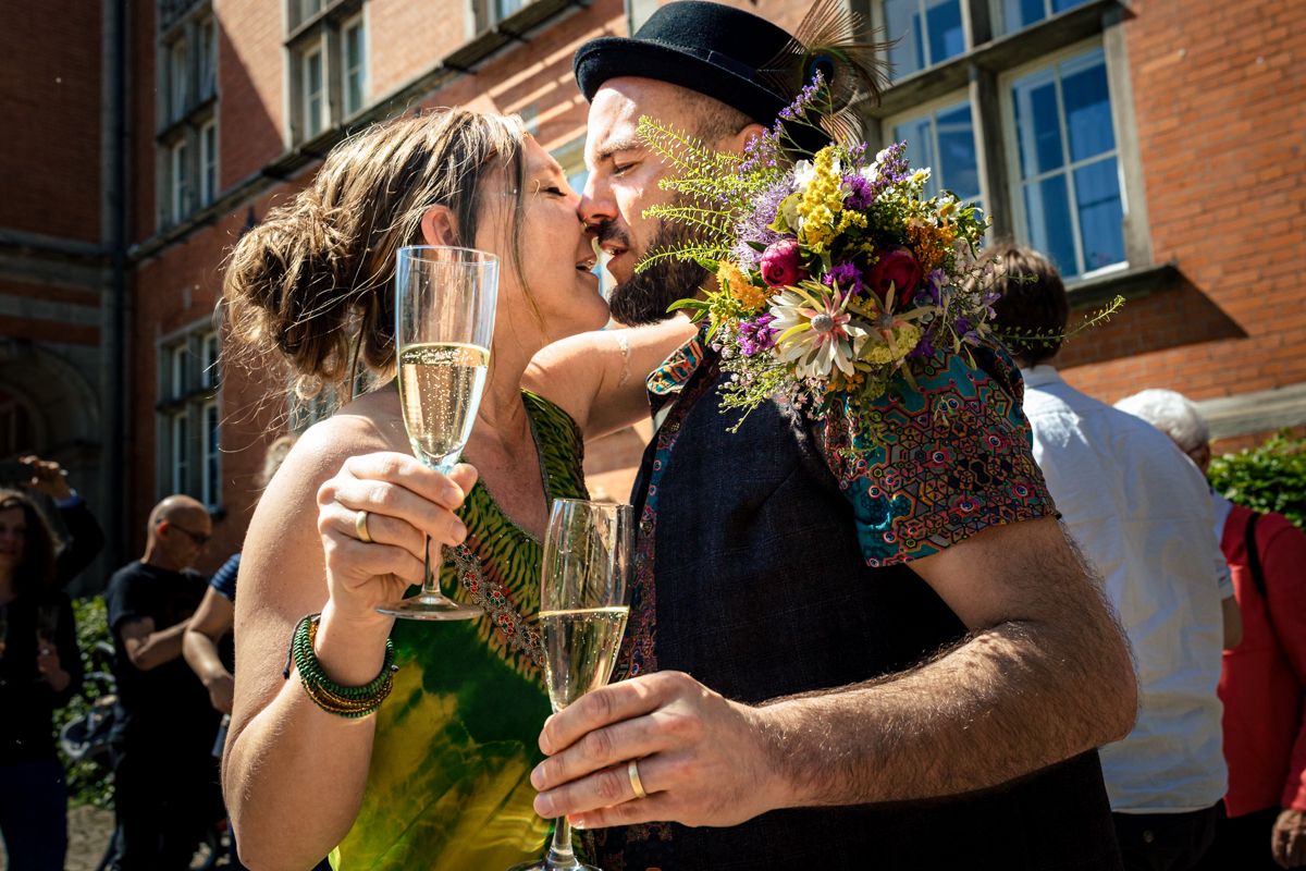 Brautpaar stößt mit Sekt an und küsst sich vor historischem Gebäude in Wilhelmsburg – Hochzeitsreportage Hamburg, Sylvia Fischer Fotografie