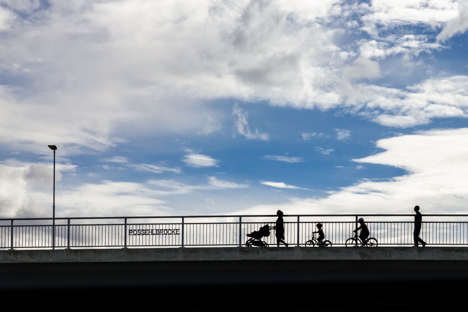 Silhouetten einer Familie auf der Possehlbrücke beim Spaziergang - Familienshooting in Lübeck