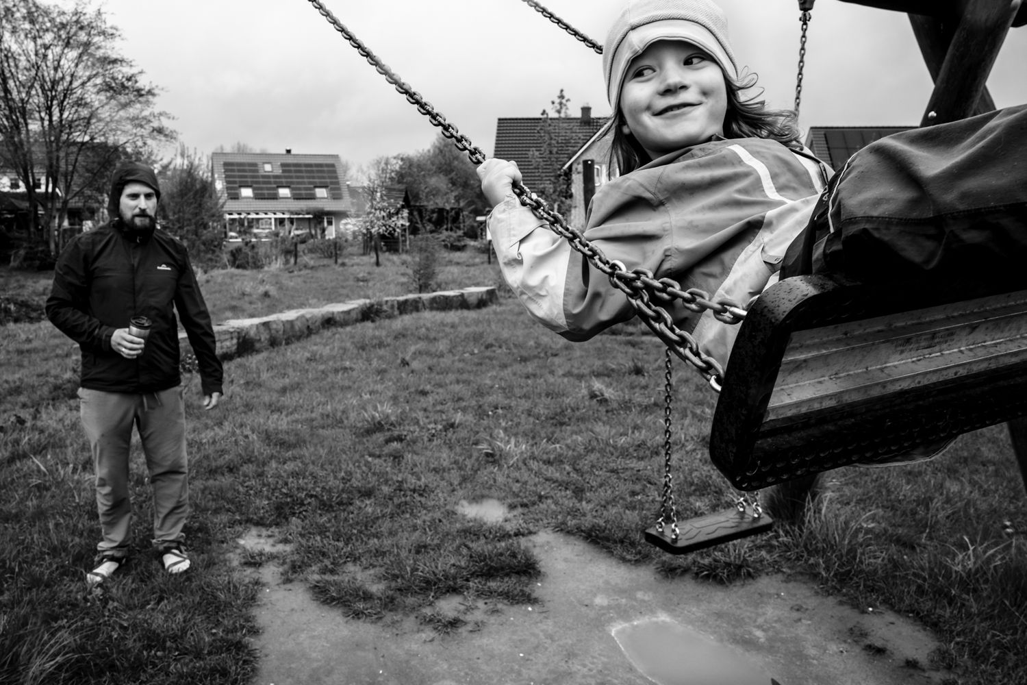 Papa gibt Kleinkind Schwung auf der Schaukel - Familienreportage Lübeck