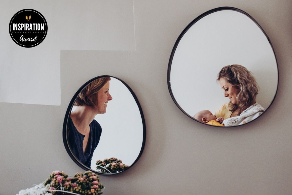Mutter mit Neugeborenem und Hebamme im Spiegel – Inspiration Photographers Award, Wochenbettfotografie Lübeck