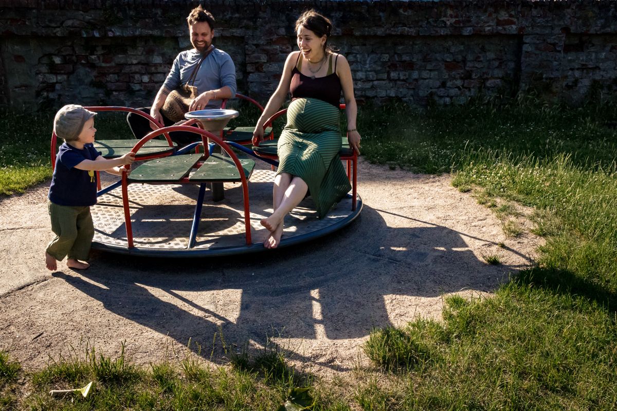 Schwangere Familie auf dem Spielplatz – Kind dreht das Karussell – Babybauchshooting Lübeck