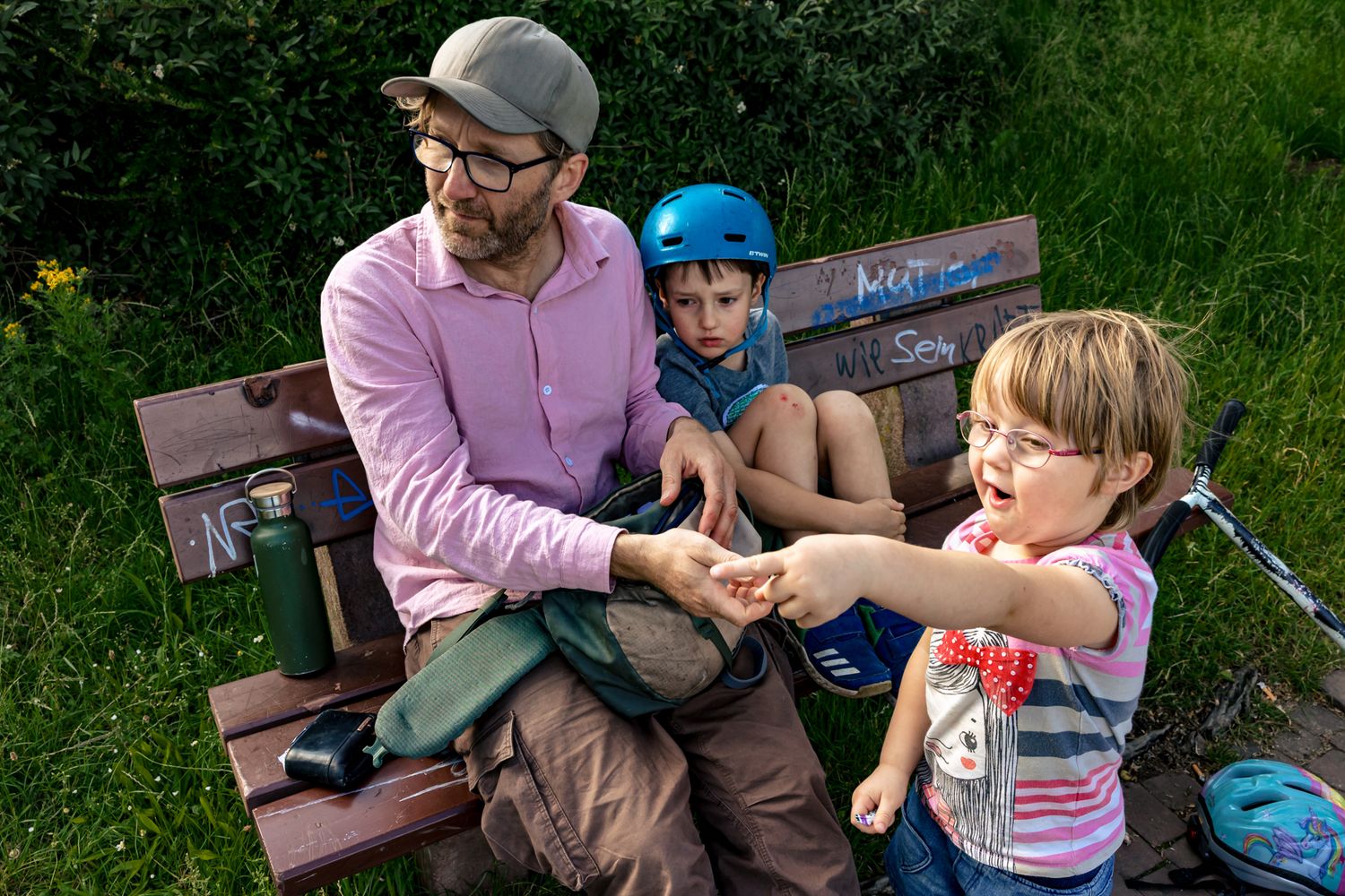 Papa mit 2 kleinen Kindern auf der Bank - Familiensession im Park