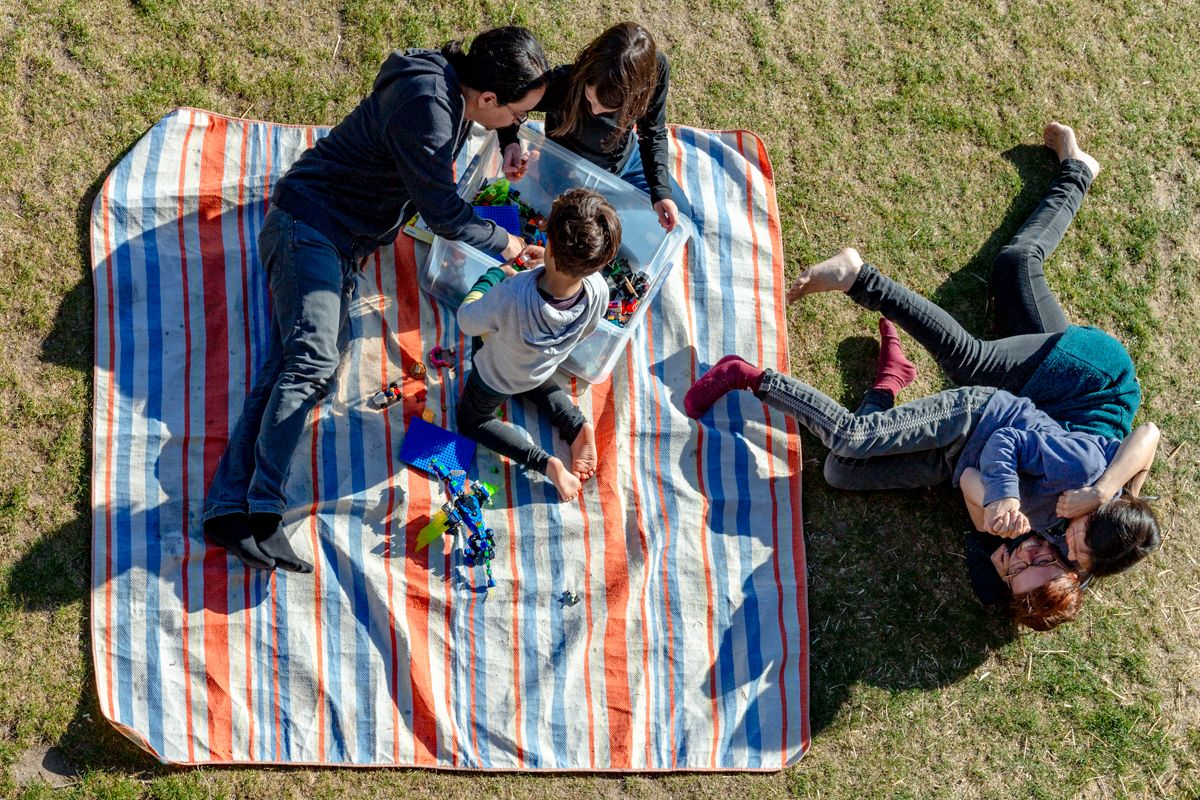 Familie auf einer Picknickdecke beim Spielen und Balgen - Familienshooting im Urlaub