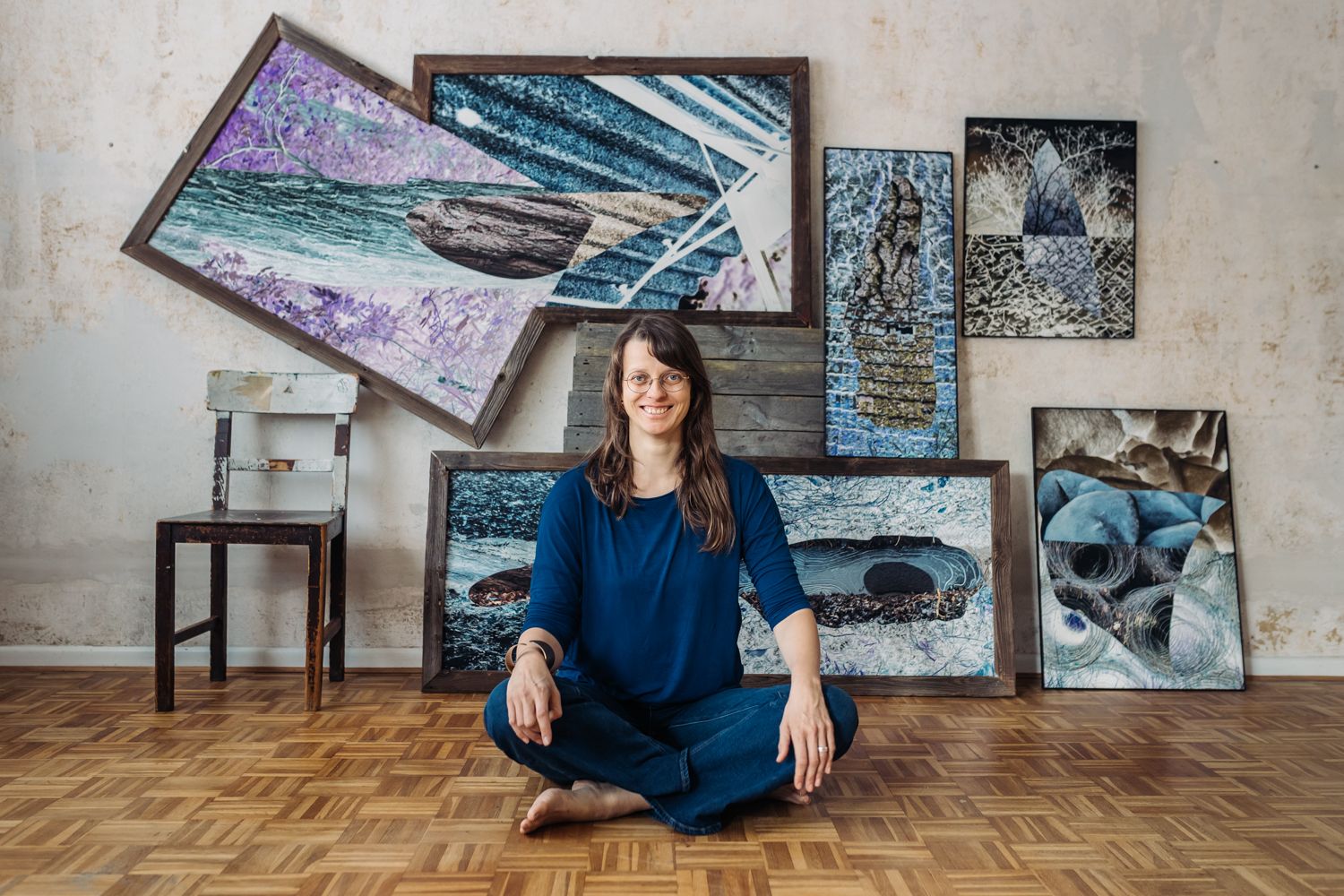 Künstlerin Imageportrait Berit Kröner vor ihren Kunstwerken sitzend