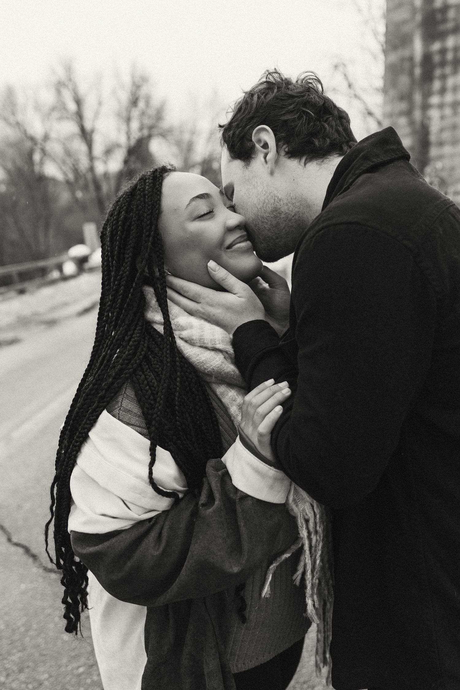 A tender romantic moment between two people sharing an intimate embrace on a winter street.
