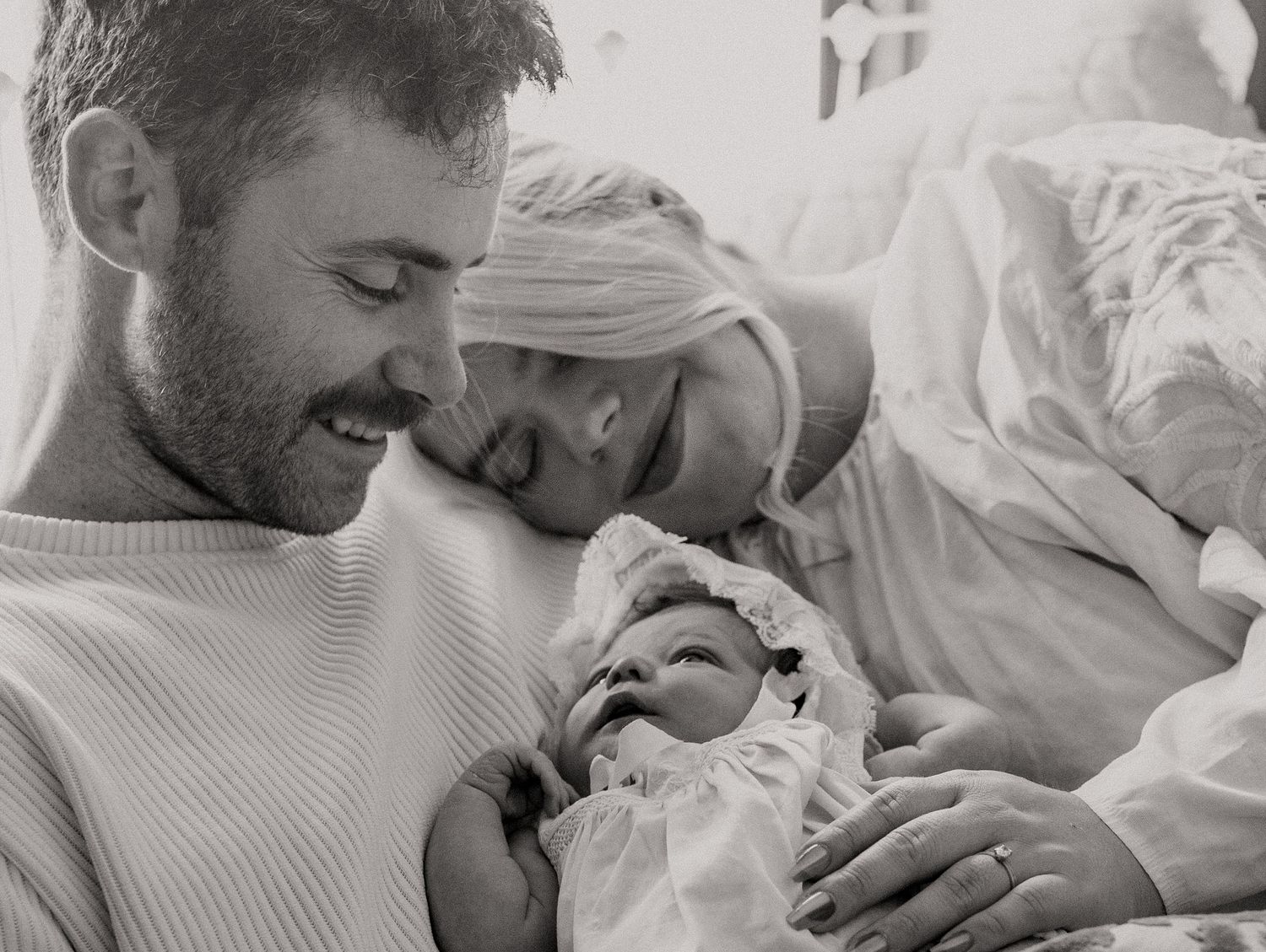 A black and white intimate moment between parents and their newborn.