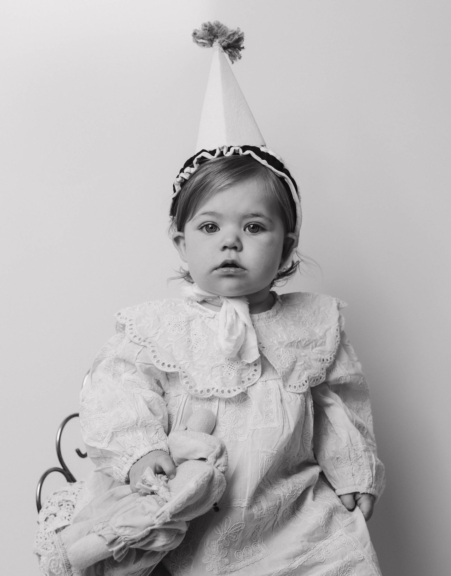 Black and white collage showcases small infant wearing vintage inspired christening gown in five different poses.