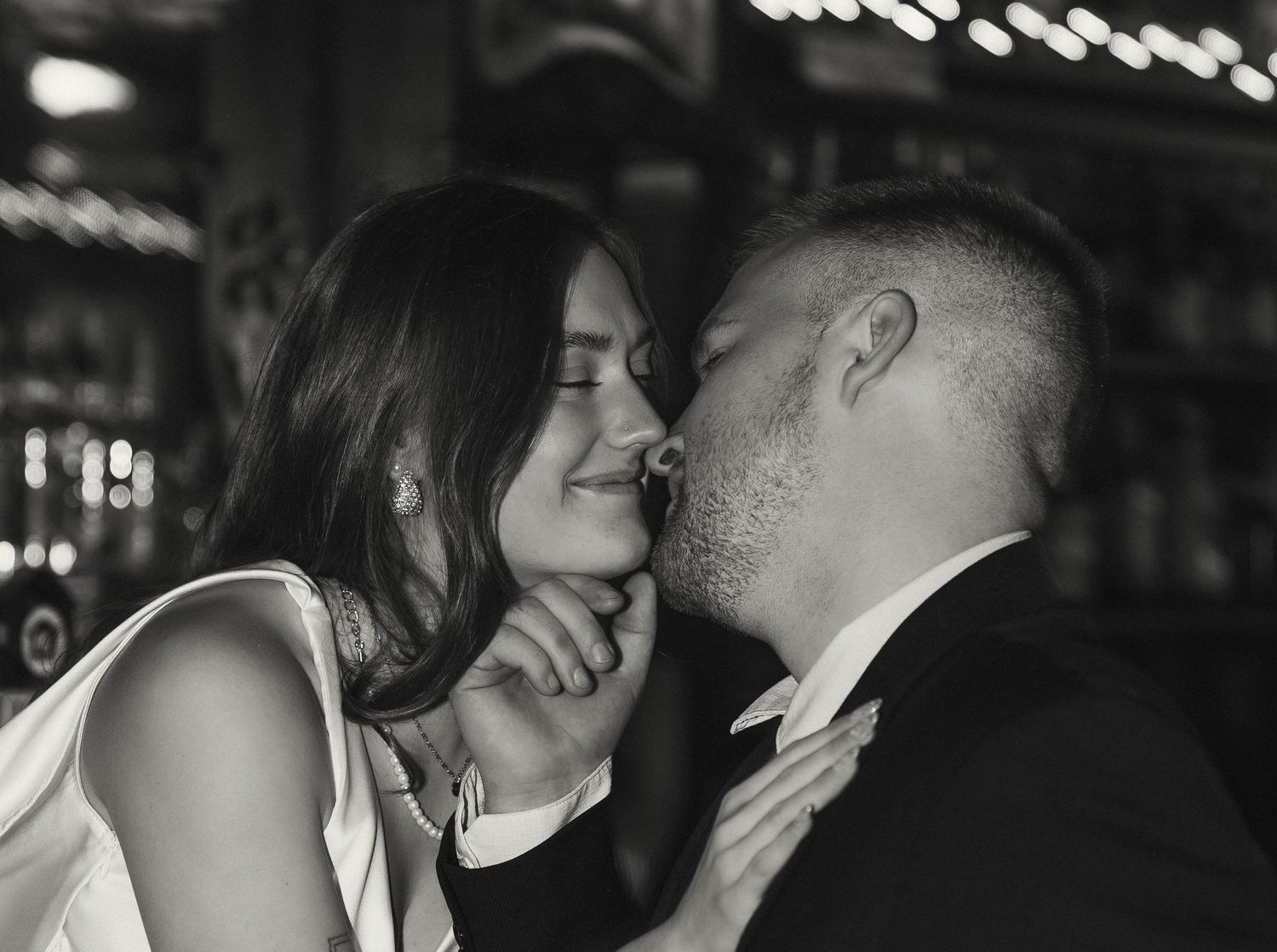 Intimate moment shared during a romantic evening in a bar setting.