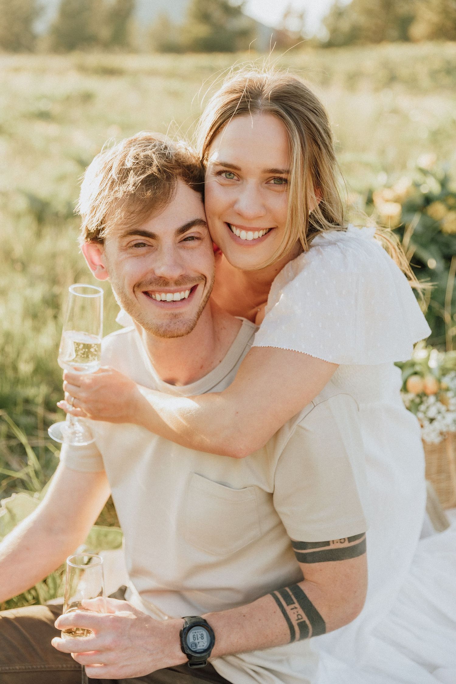 a happy couple enjoys a picnic in the golden light during their engagement session