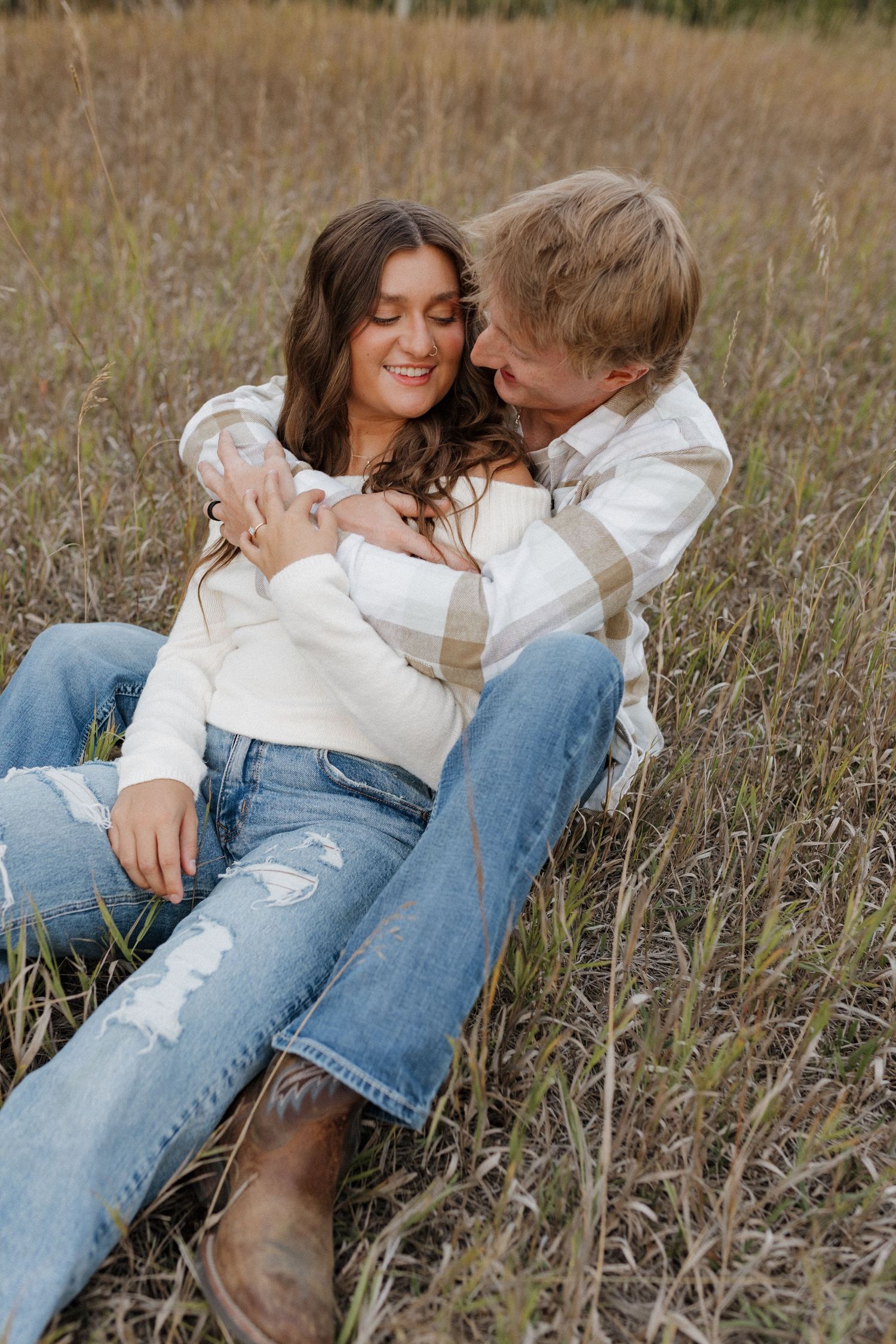 Couple in casual wear sharing loving moment in autumn field.