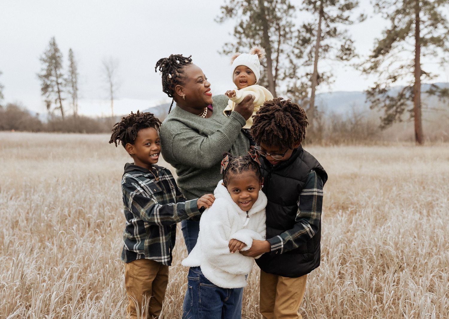 Joyful family playing and laughing together in a natural outdoor setting.