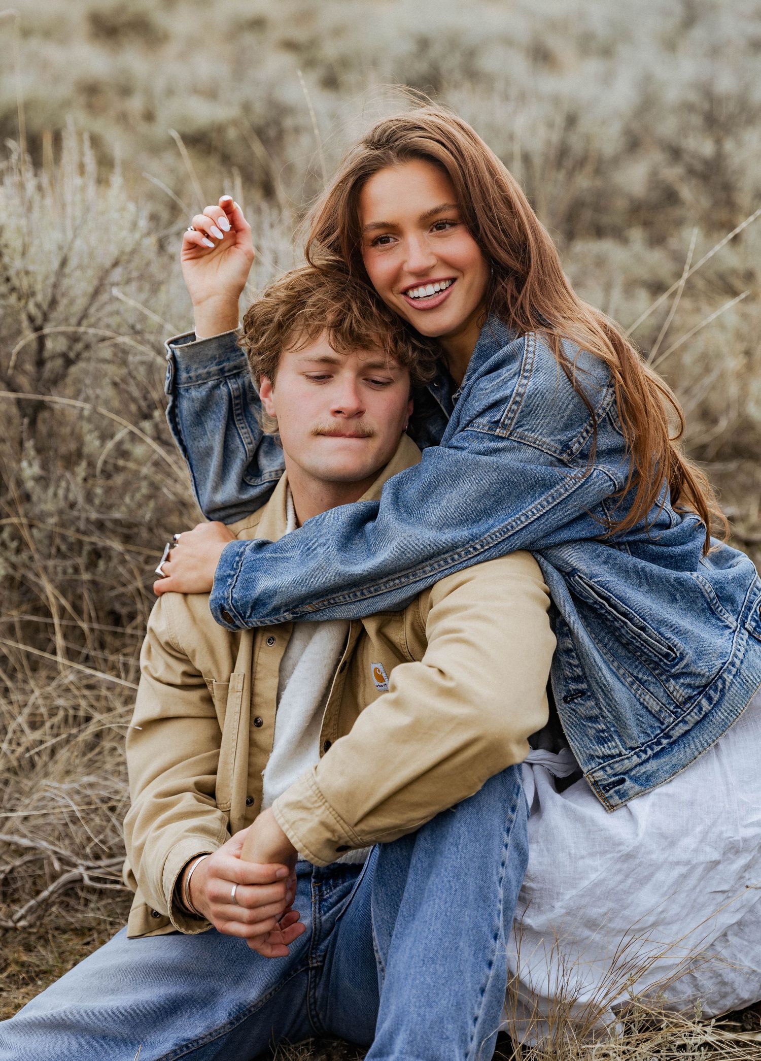 A cheerful embrace captured against rustic mountain scenery.