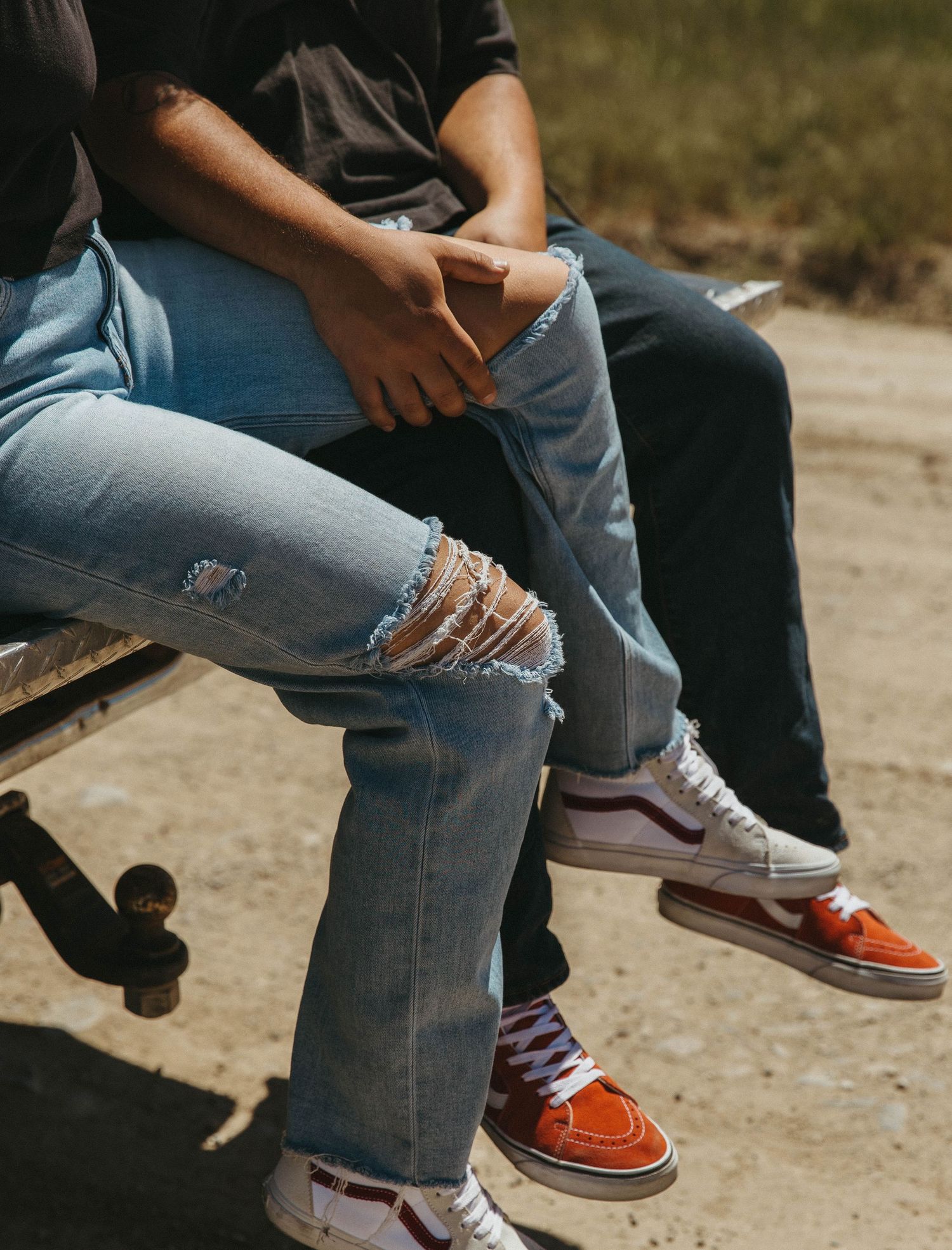 Five connected images showing blue ripped jeans and orange and black casual sneakers in various close-up angles.