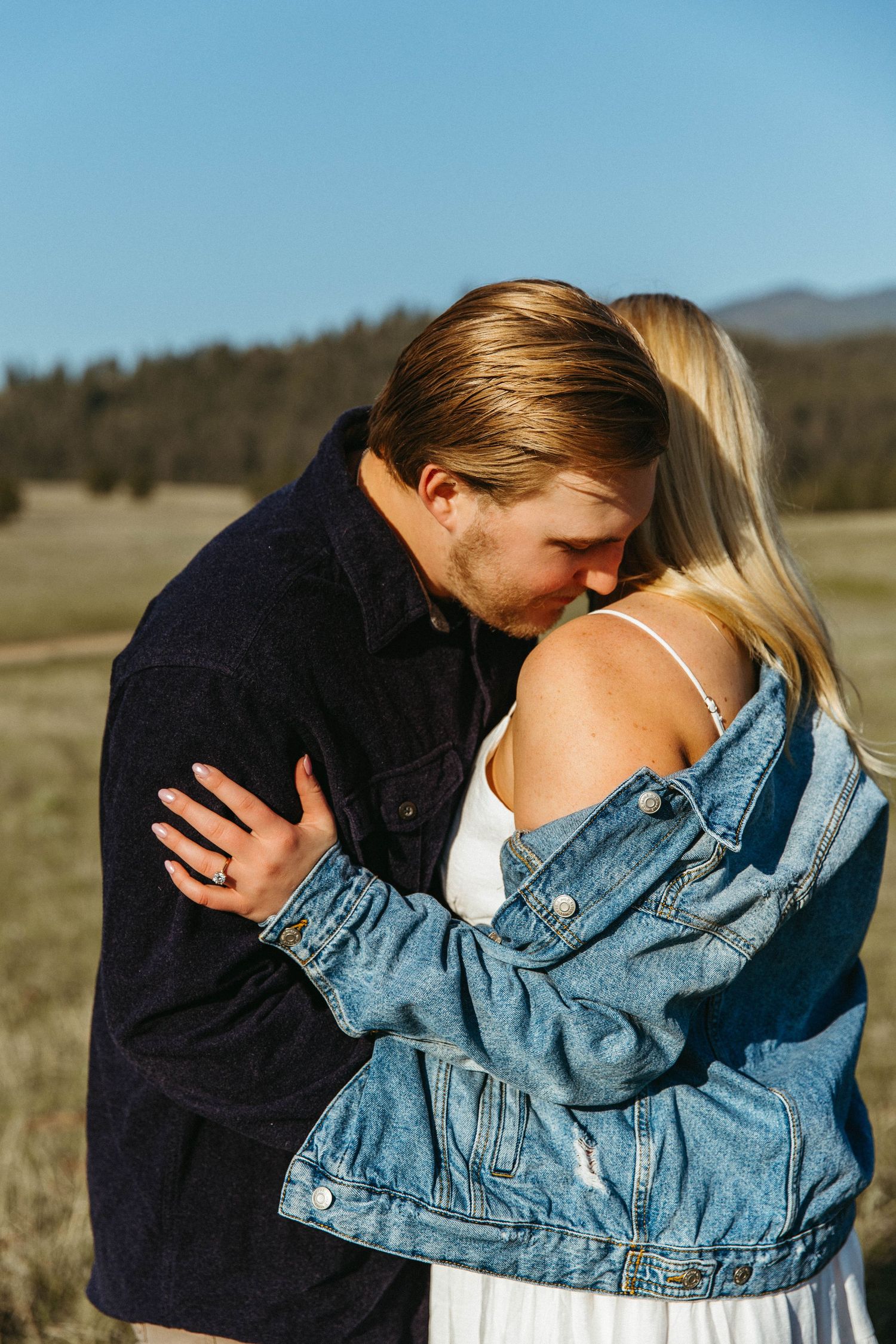 Four connected images showing a romantic moment between two people wearing denim jackets in an outdoor field setting.