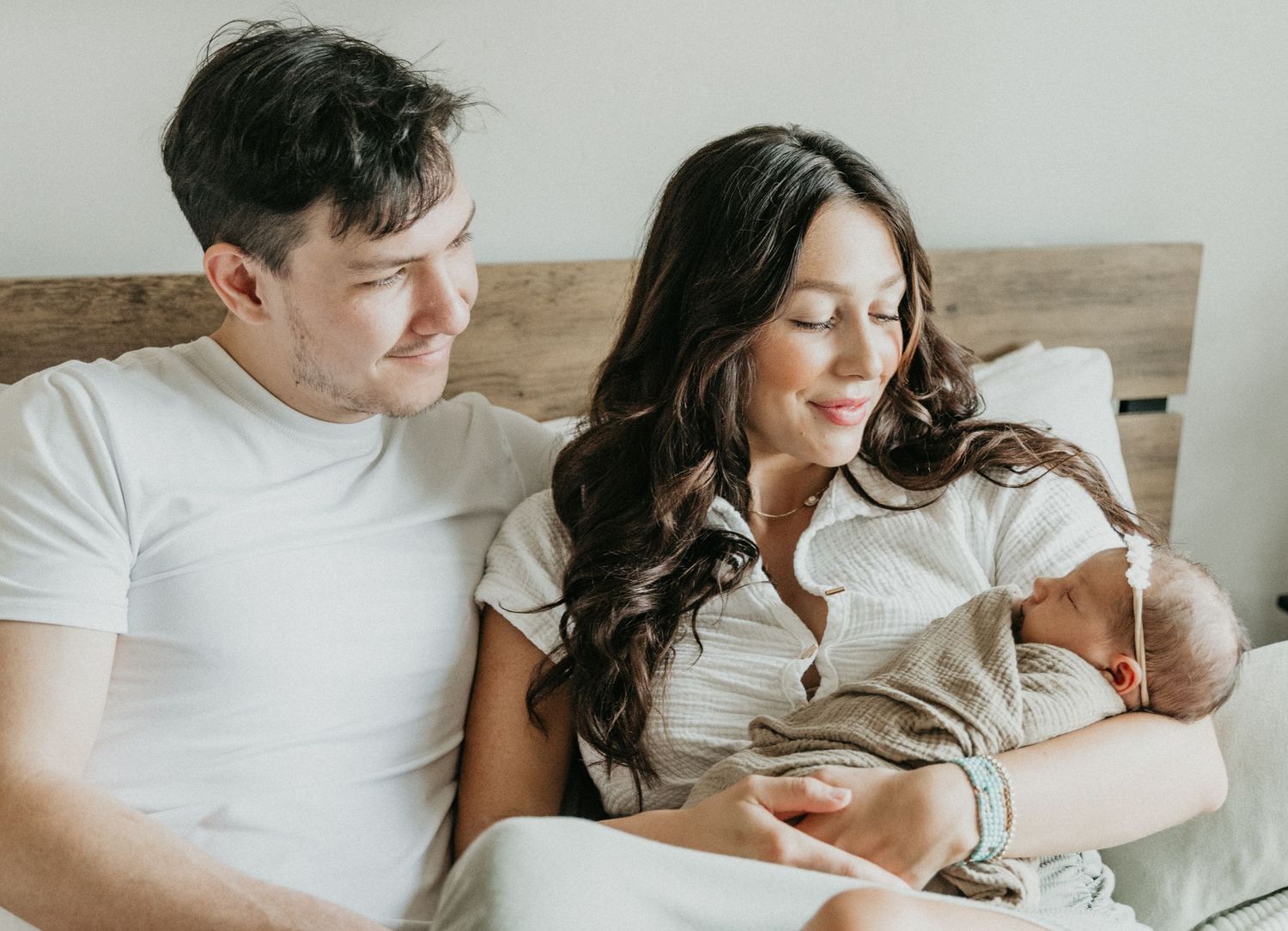 a new family of three shares smiles and cuddles during their in home session