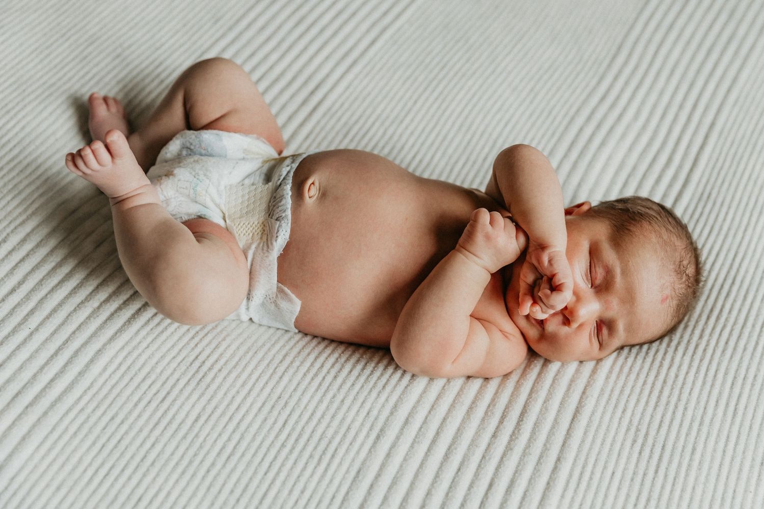 a sweet newborn sleeps peacefully during her in home newborn session