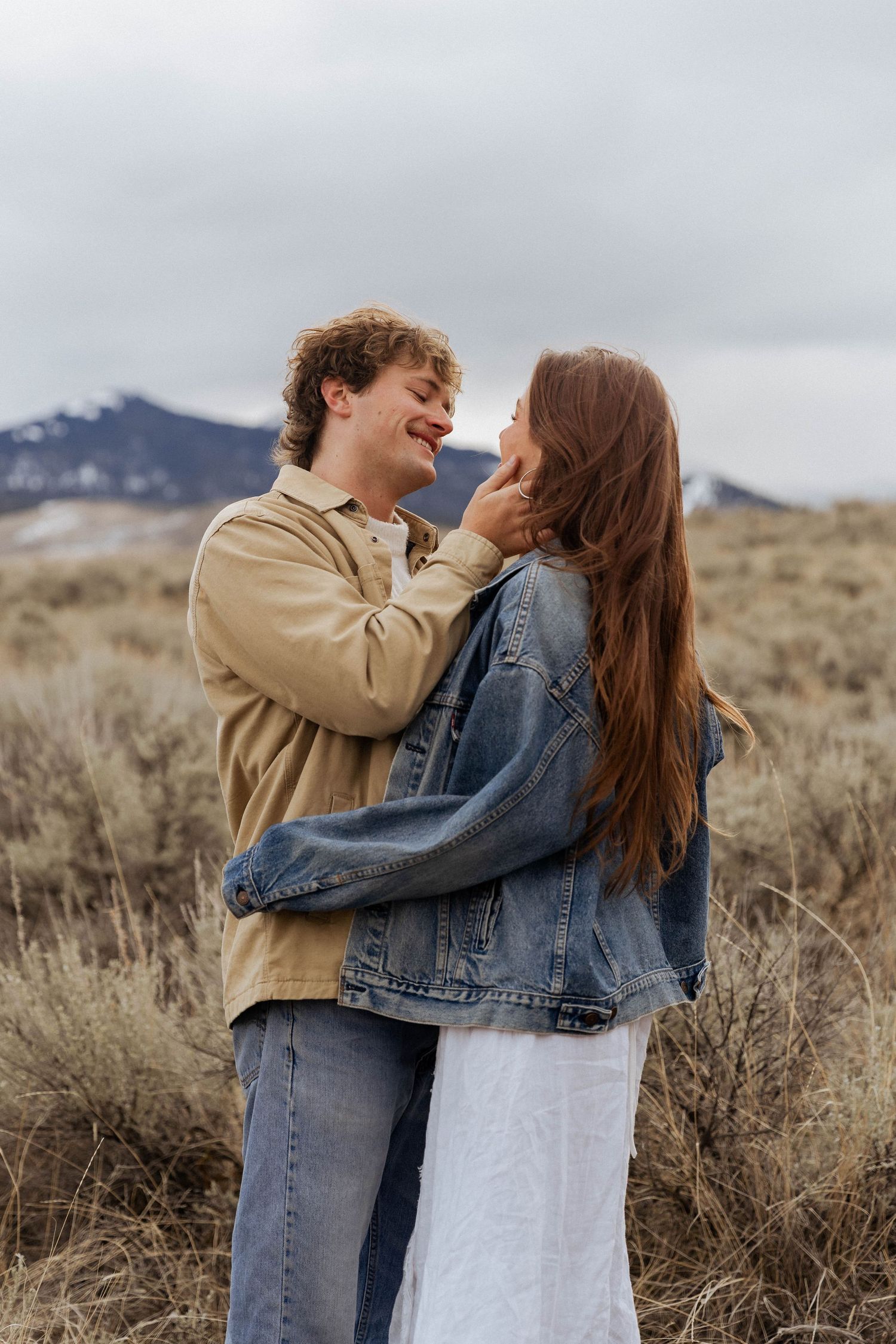 A candid moment of joy and laughter shared in a mountain field.
