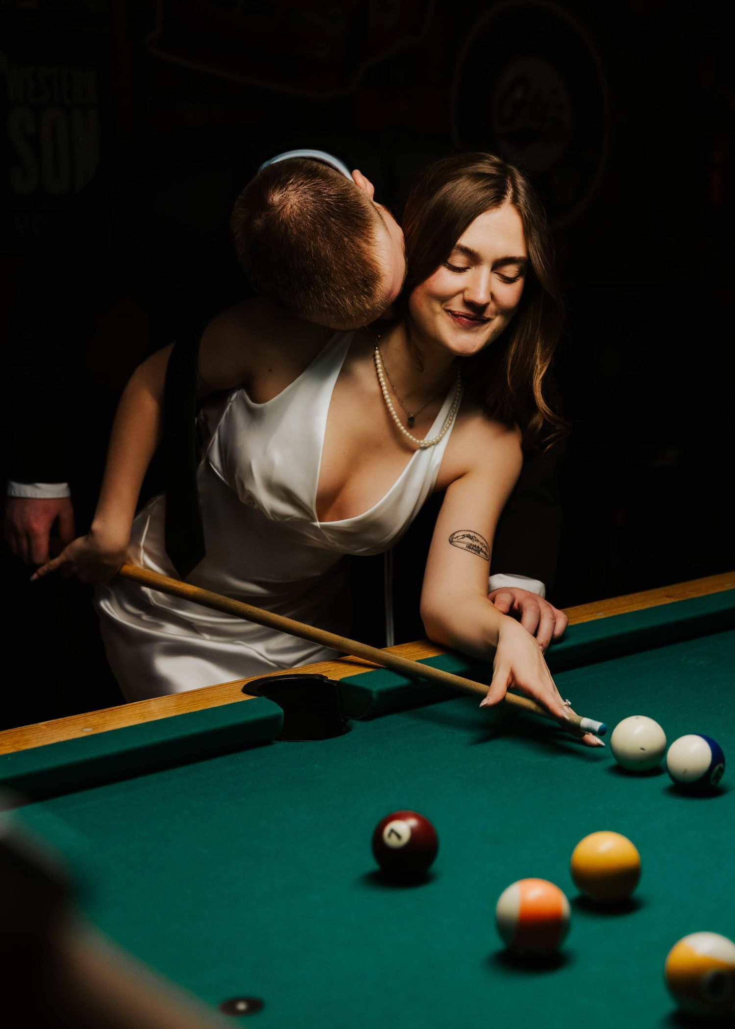 Romantic scene at a pool table with couple enjoying a game together.
