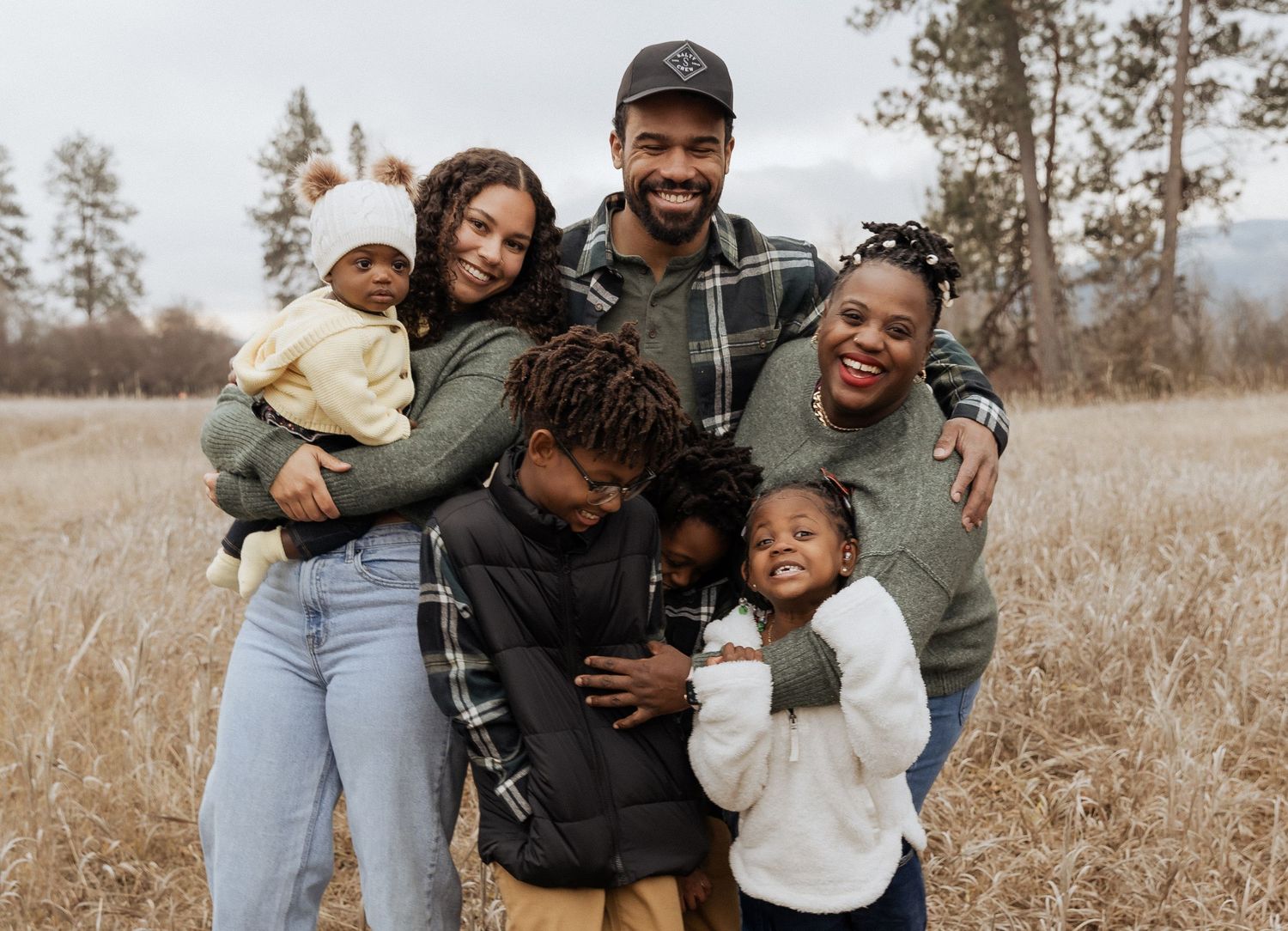 Candid family portrait showing playful moment outdoors in nature.