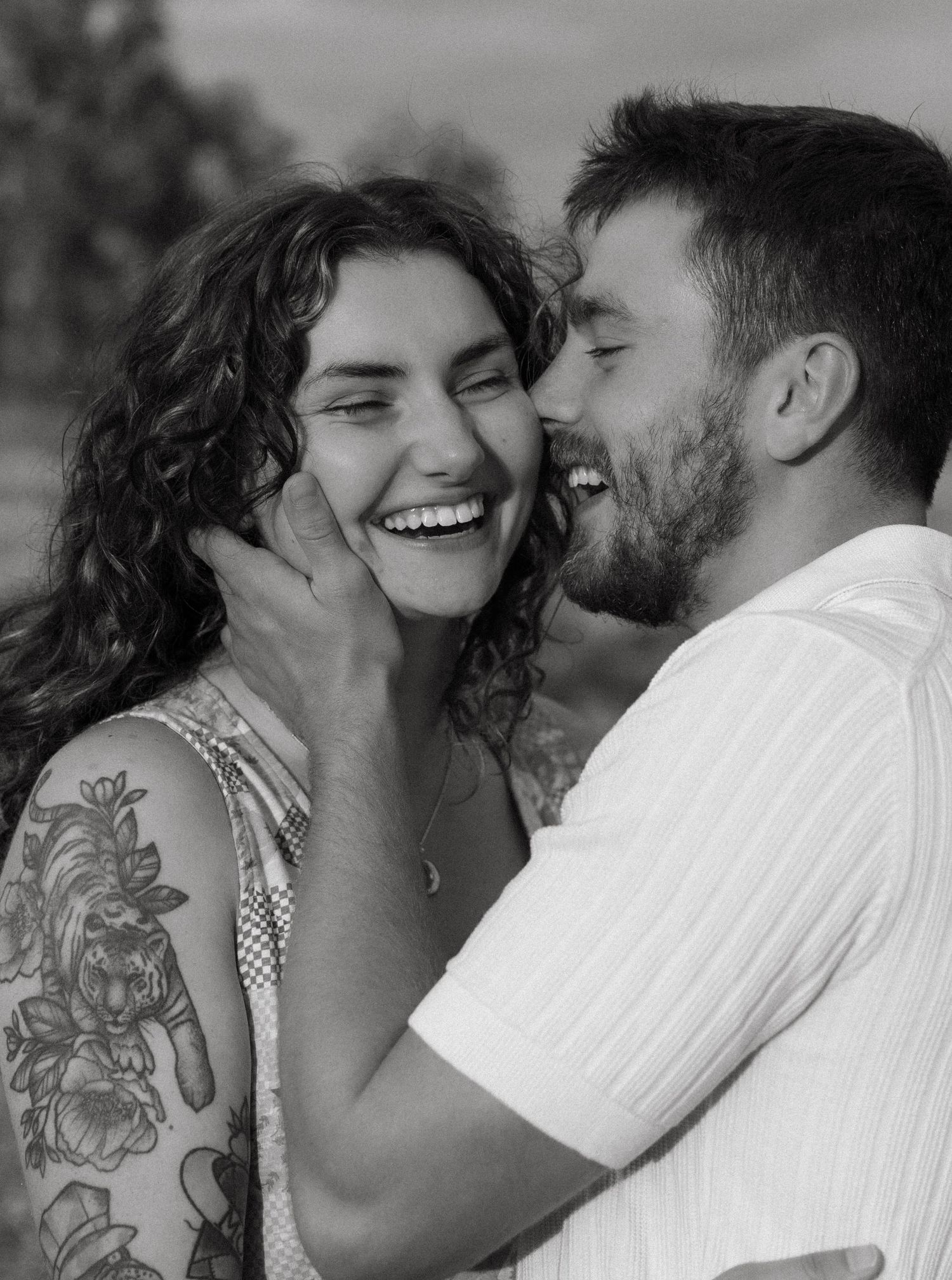 Black and white intimate photo series showing close-up moments between a tattooed couple sharing tender moments together.