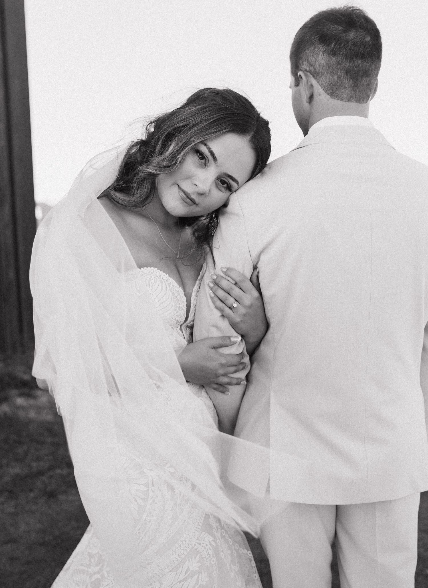 A romantic black and white wedding portrait showing tender moment between newlyweds.