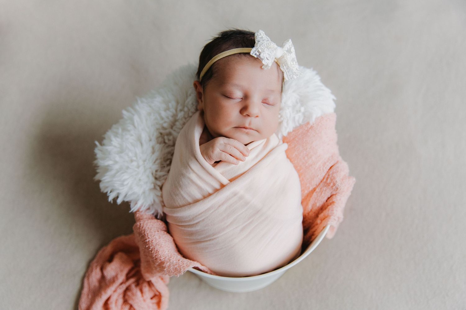 a newborn is perfectly swaddled and sleeping in the natural light during her studio session