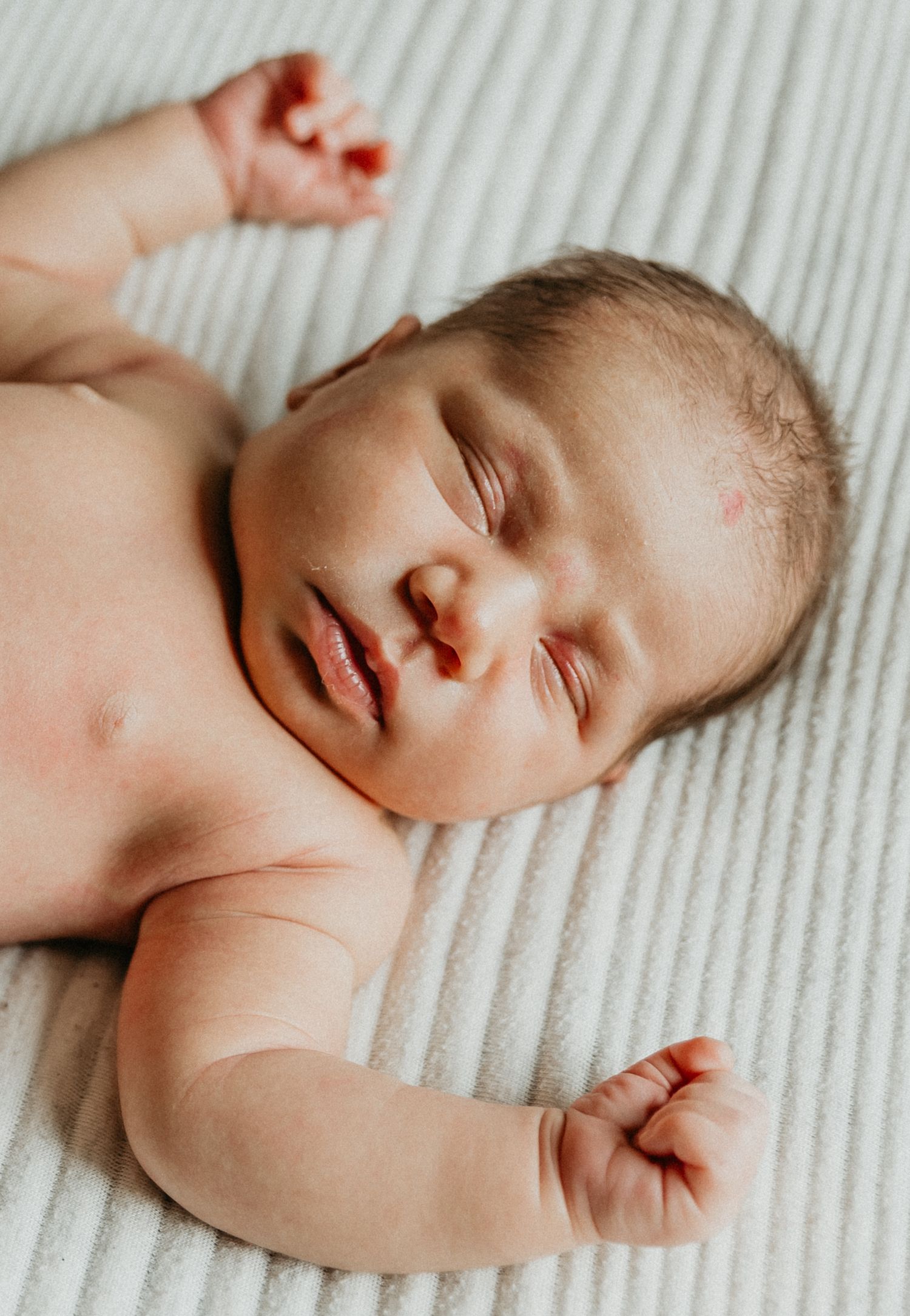 a sweet newborn sleeps peacefully during her in home newborn session