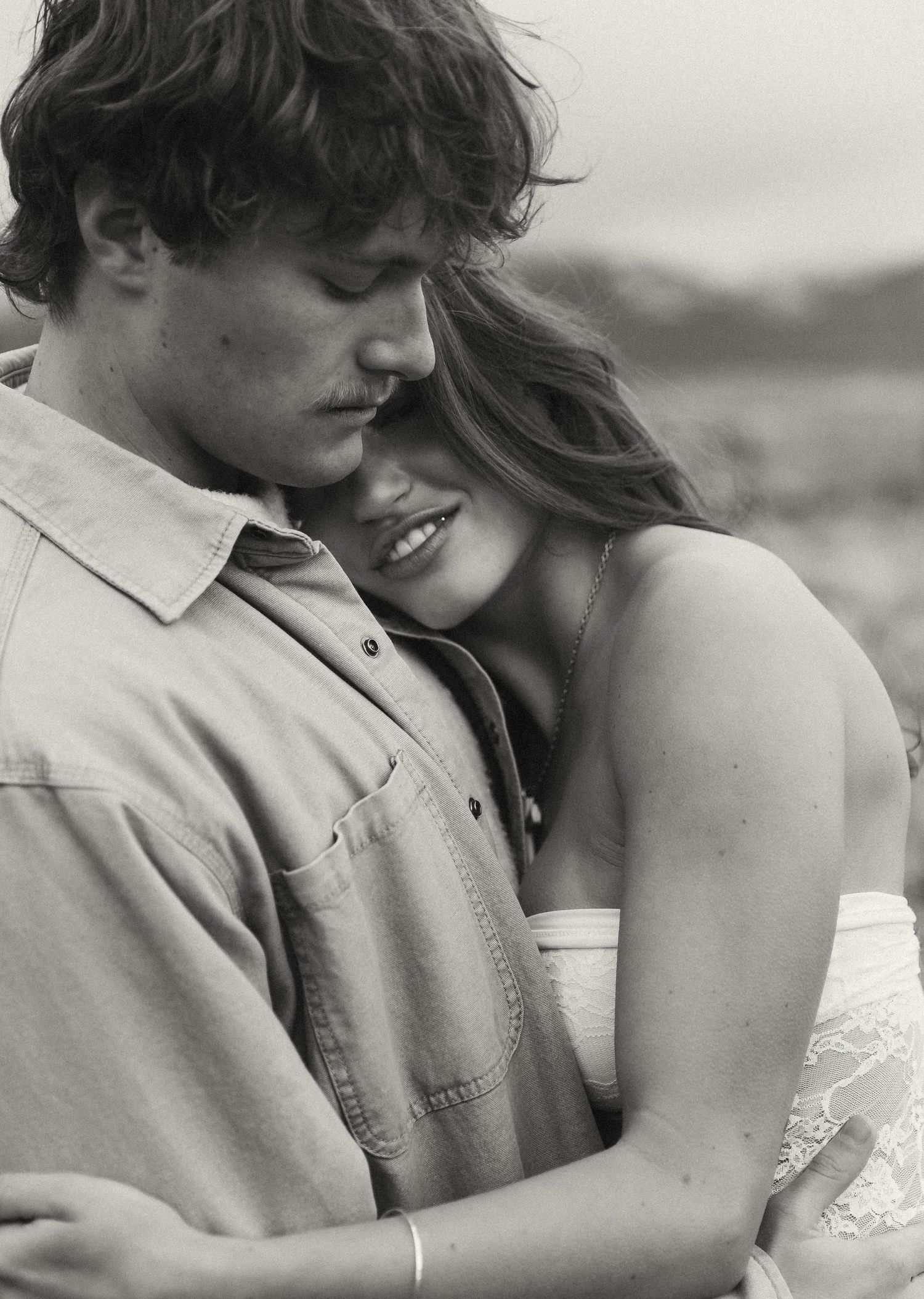 An intimate black and white portrait showing a tender romantic moment.