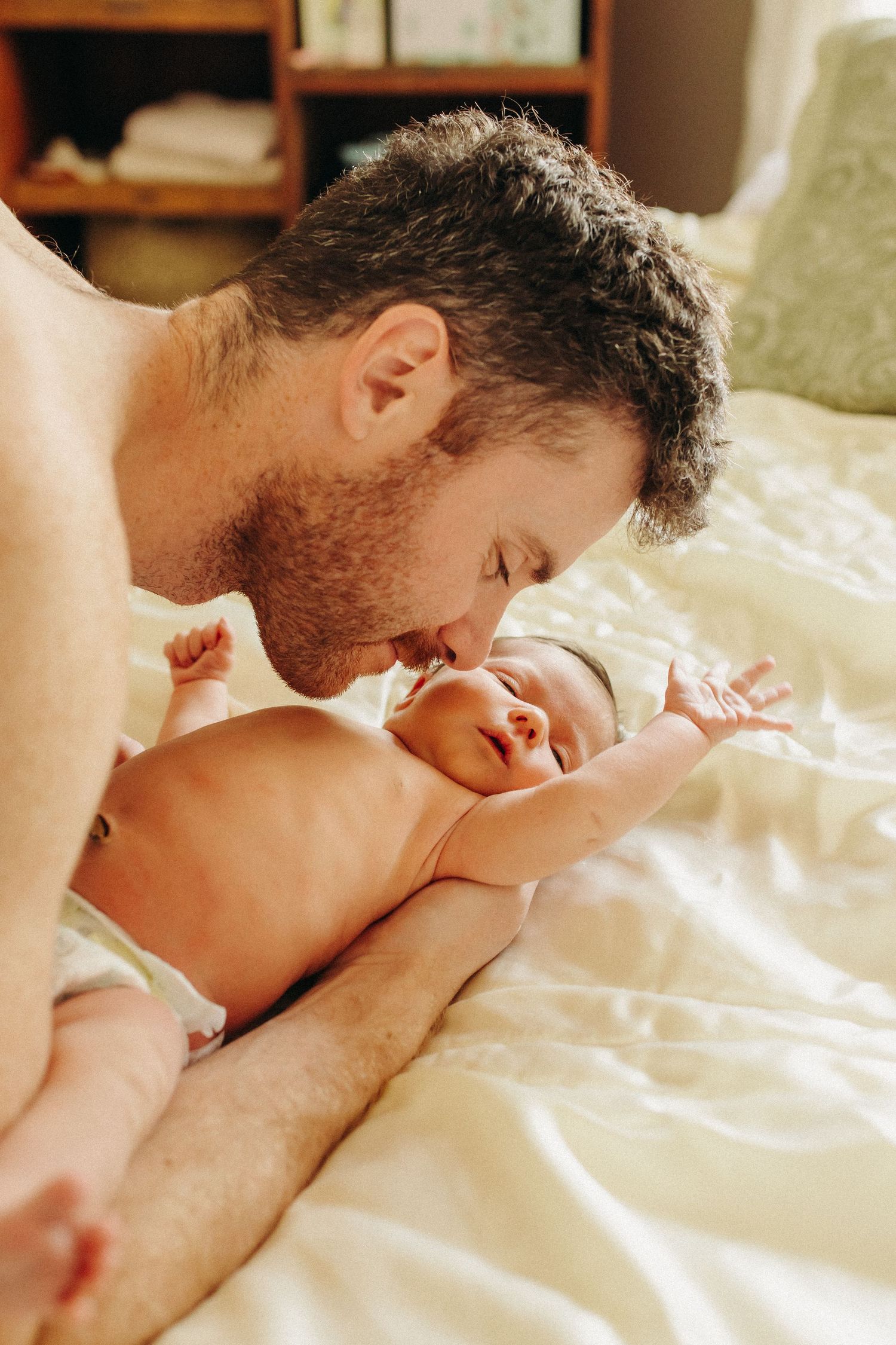 a father snuggles his baby girl in the warm light