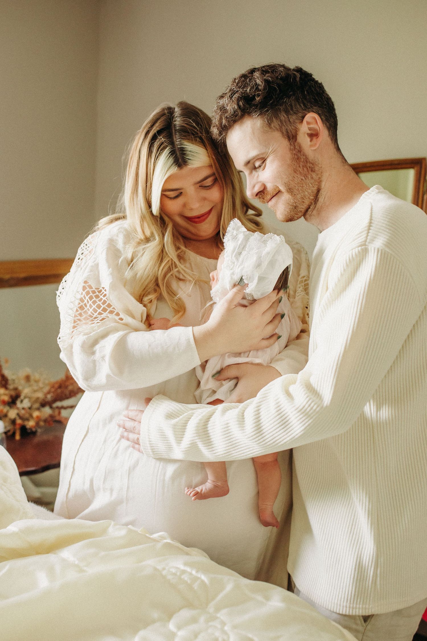 a new family of three shares smiles and cuddles during their in home session- nostalgic, vintage inspired.