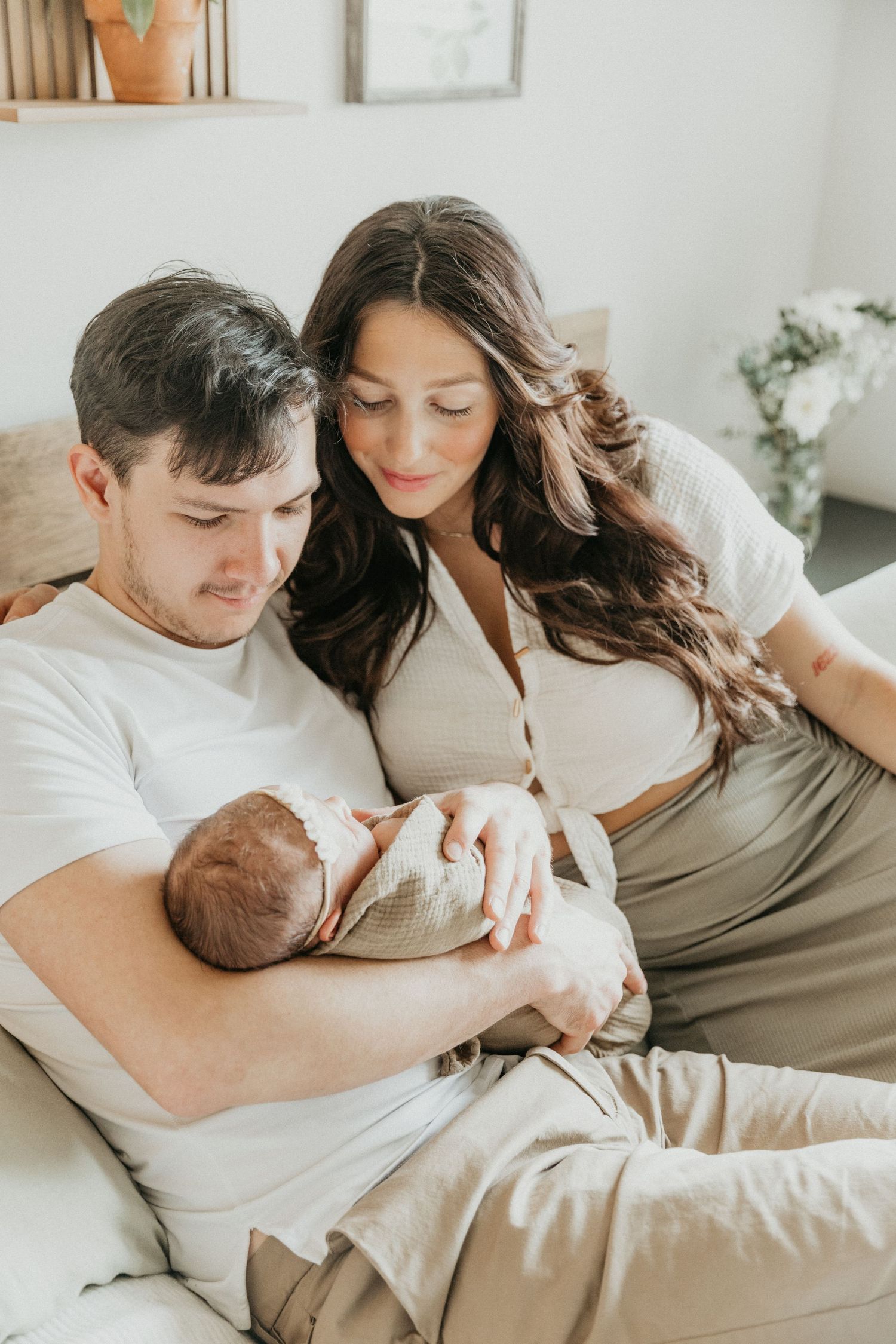 a new family of three shares smiles and cuddles during their in home session
