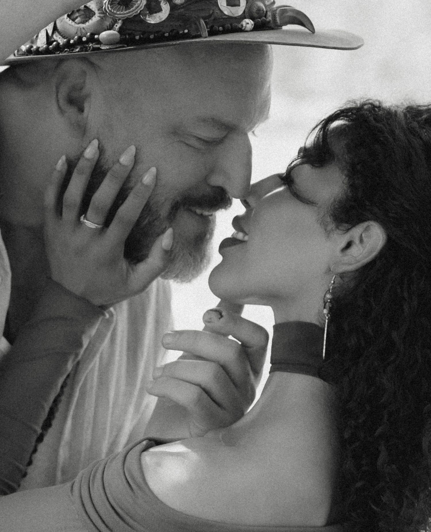 A romantic black and white image showing an intimate moment between two people in a close embrace.