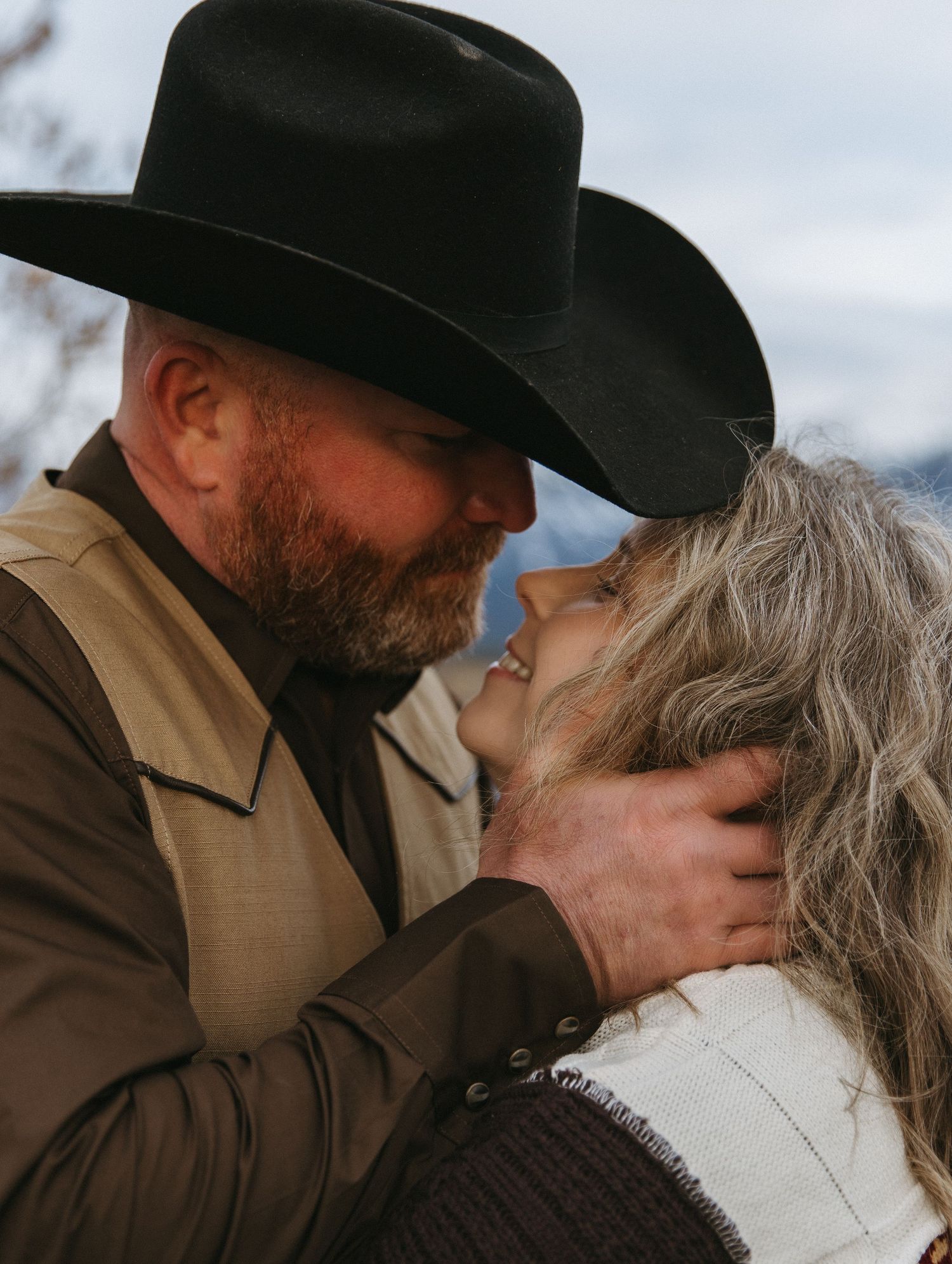 Intimate couple shares tender moments in a series of romantic portraits with mountains in background.