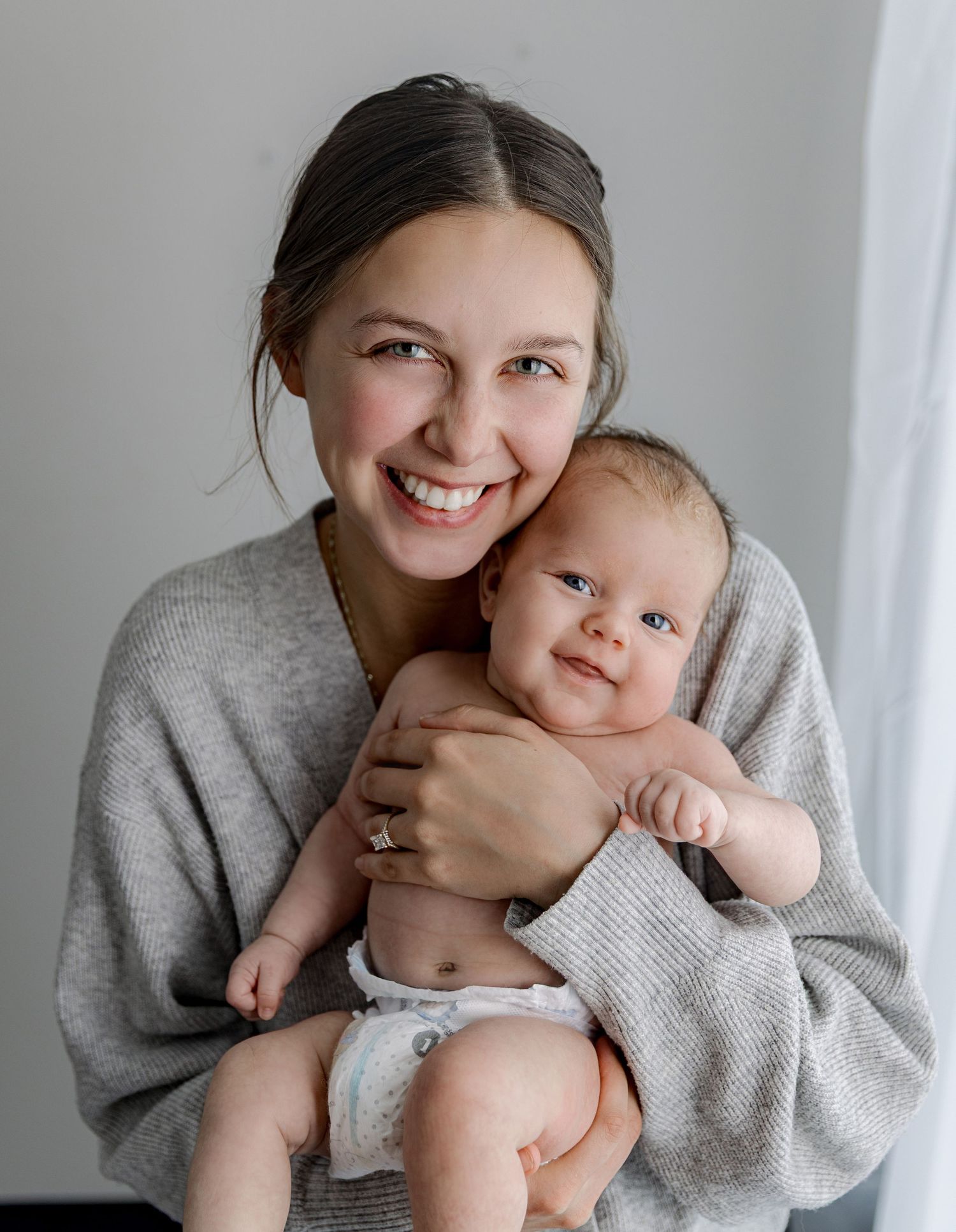 Mother in grey sweater cuddling and playing with baby in series of tender moments.