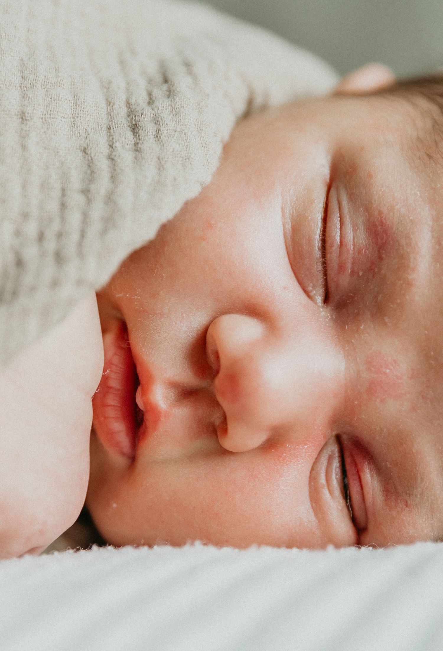 a sweet newborn sleeps peacefully during her in home newborn session