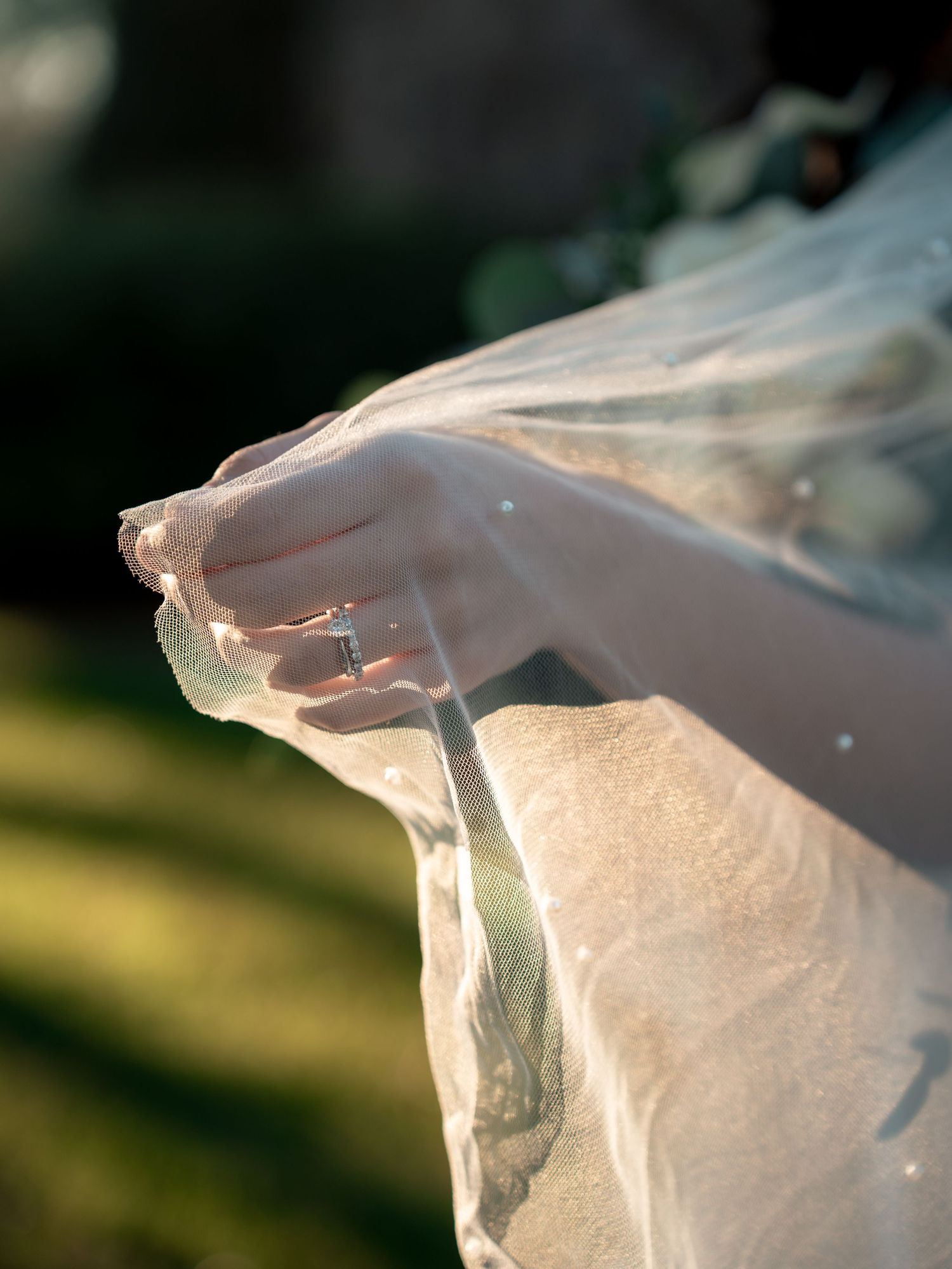 A white plastic bag flutters in the wind against a blurred natural background, creating an ethereal motion effect.