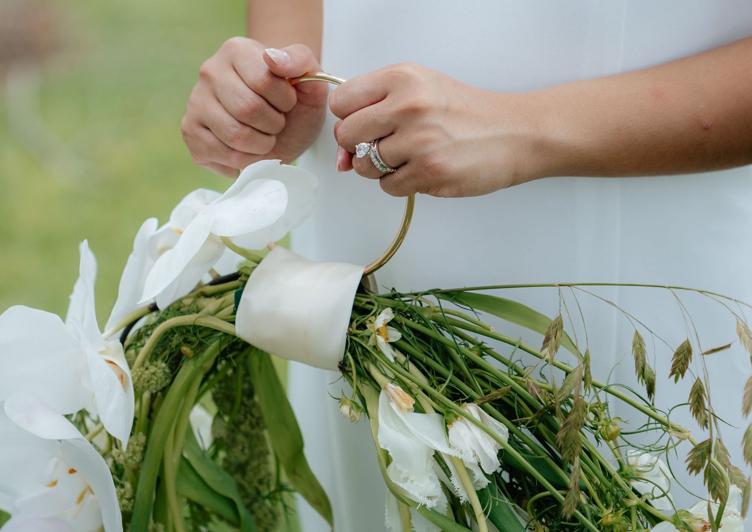 Close-up details of delicate white flowers and greenery in a wedding bouquet.