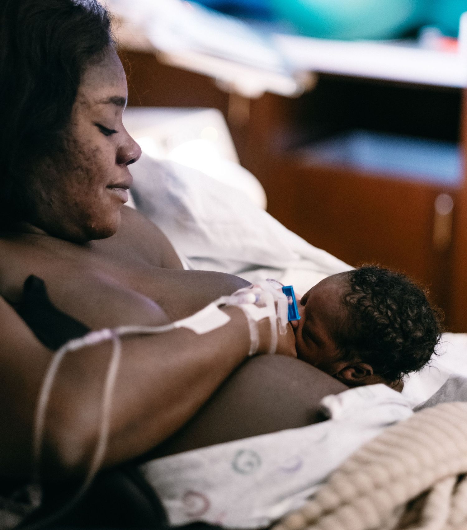 Patient resting in hospital bed while receiving medical care.